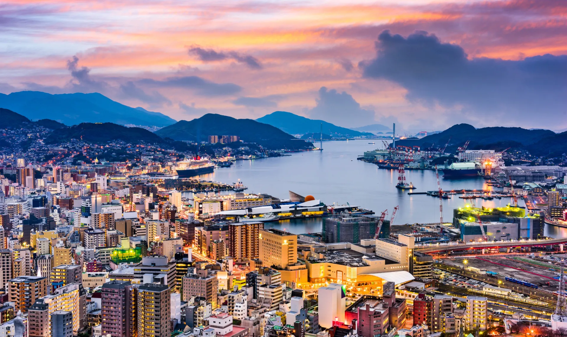 Vista panorâmica da cidade moderna de Nagasaki, com seus prédios e porto movimentado.