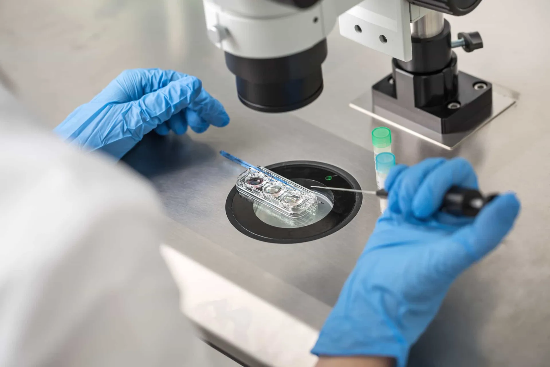 Um cientista em um laboratório olhando através de um microscópio, representando a ciência da fertilização in vitro.