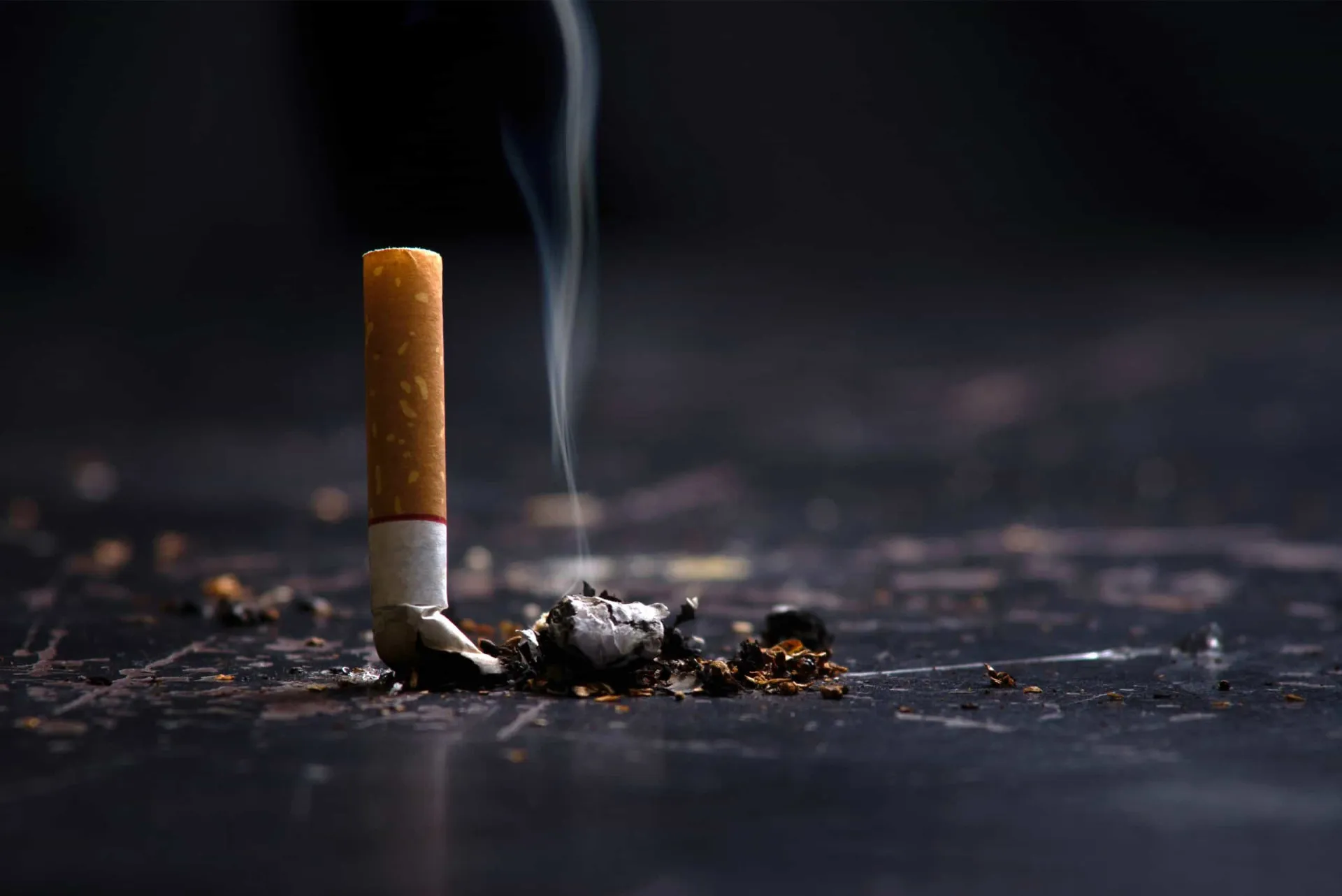 Um cinzeiro cheio de bitucas de cigarro, simbolizando os efeitos nocivos do tabagismo na saúde.