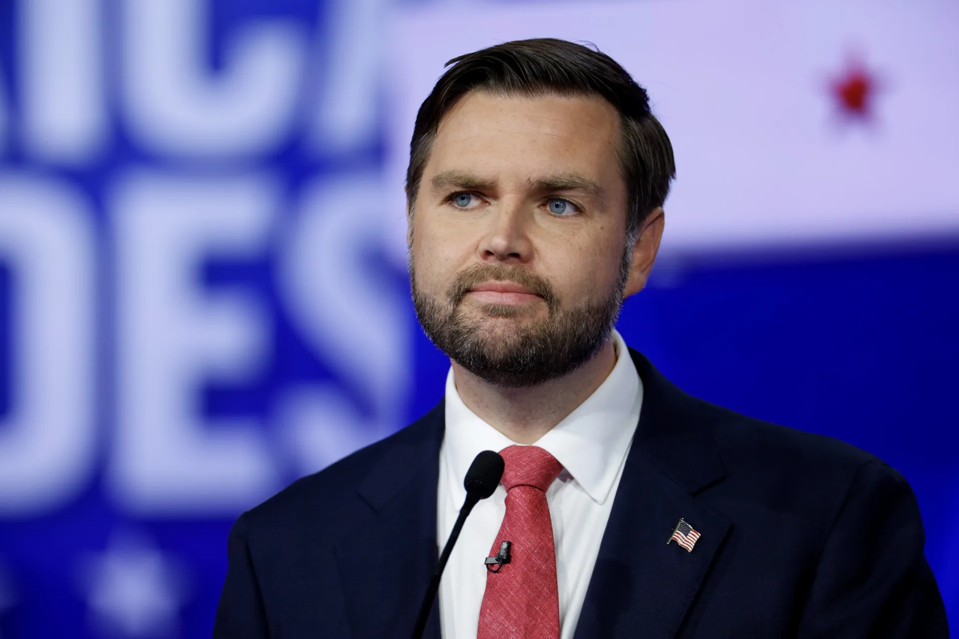 JD Vance acenando para uma multidão durante um comício de campanha.