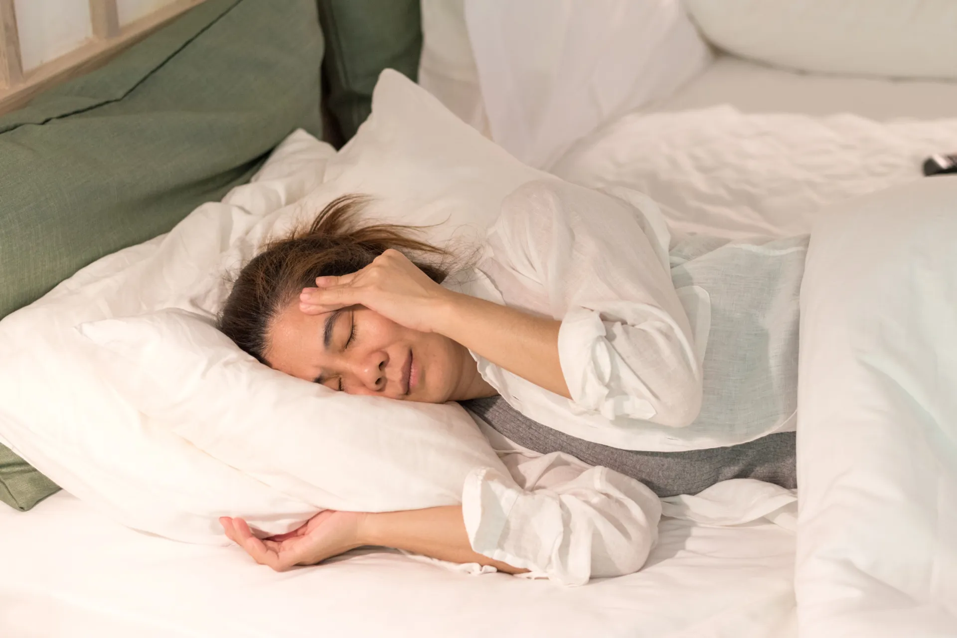 Pessoa deitada em uma cama de hospital com os olhos fechados, simbolizando a perda de consciência após um AVC.
