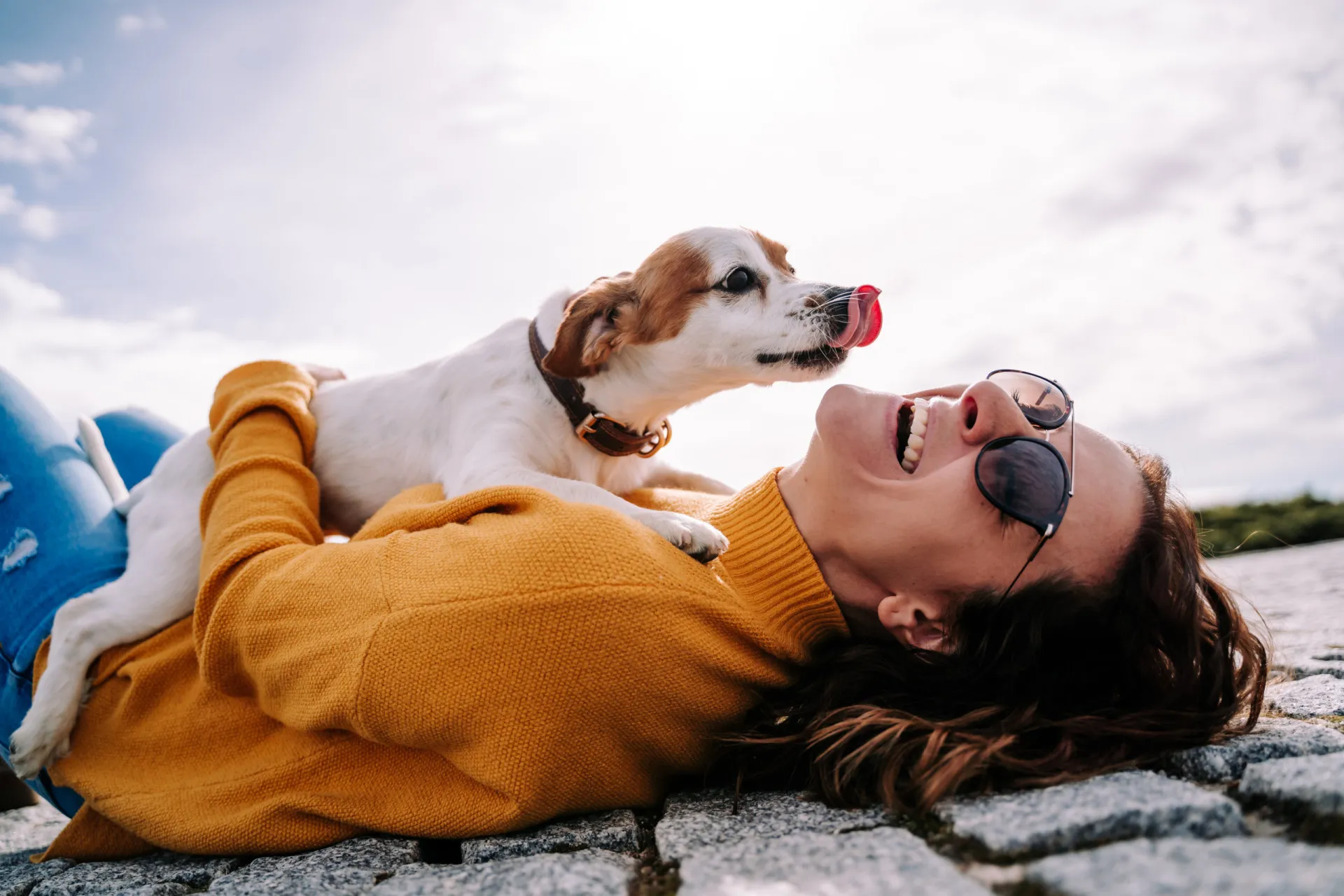 Mulher praticando um esporte radical com seu cachorro correndo ao lado.