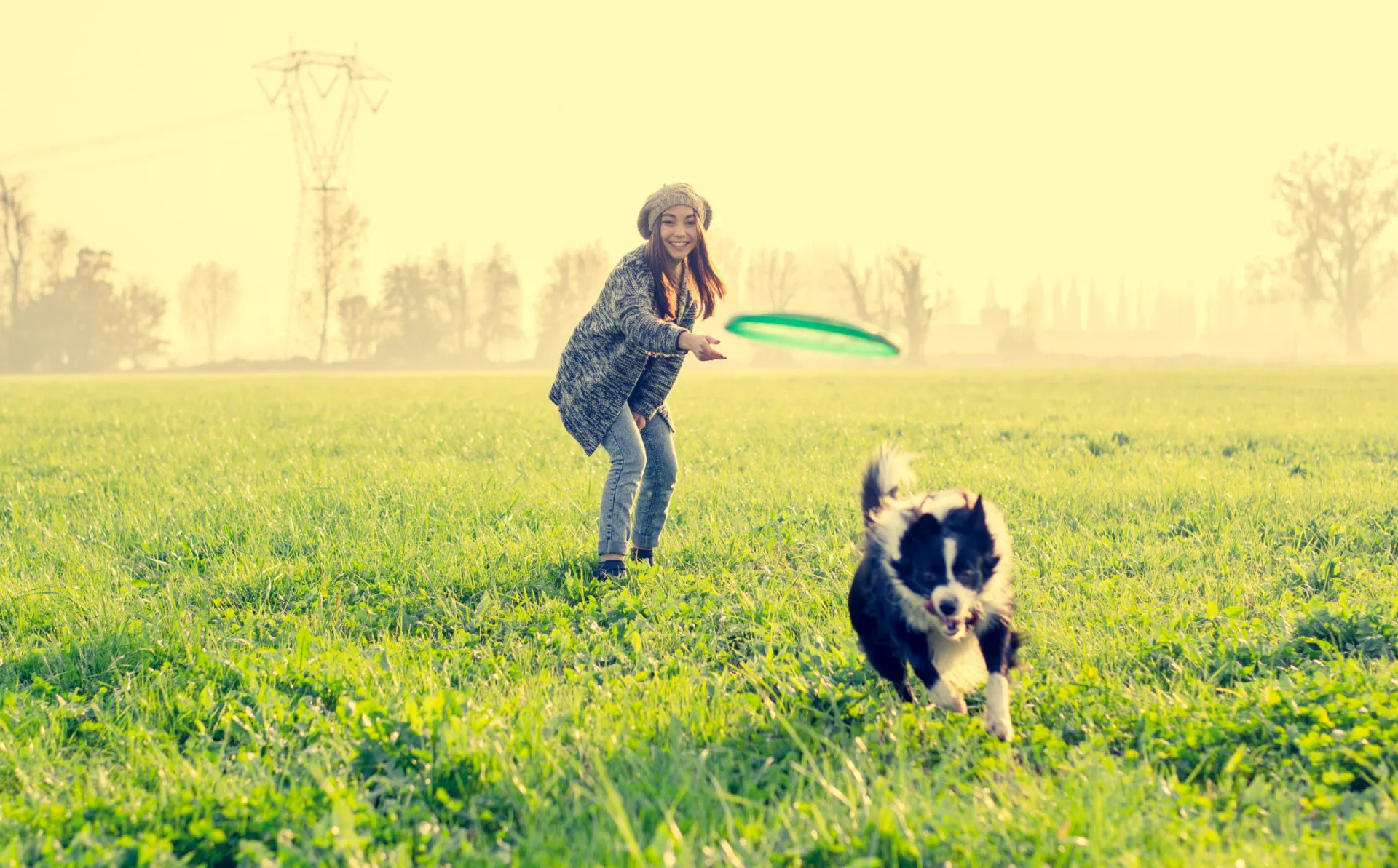 Mulher correndo em um parque com seu cachorro, ambos cheios de energia.