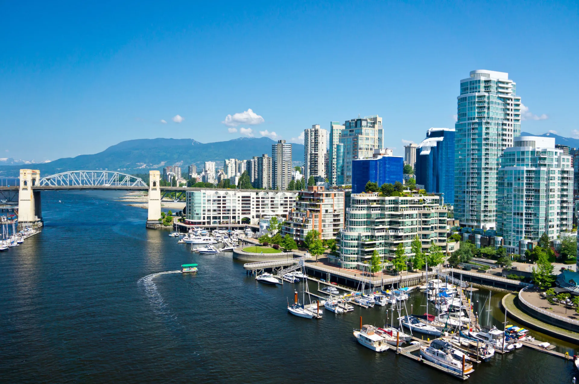 Vista da cidade de Vancouver com montanhas e mar ao fundo.