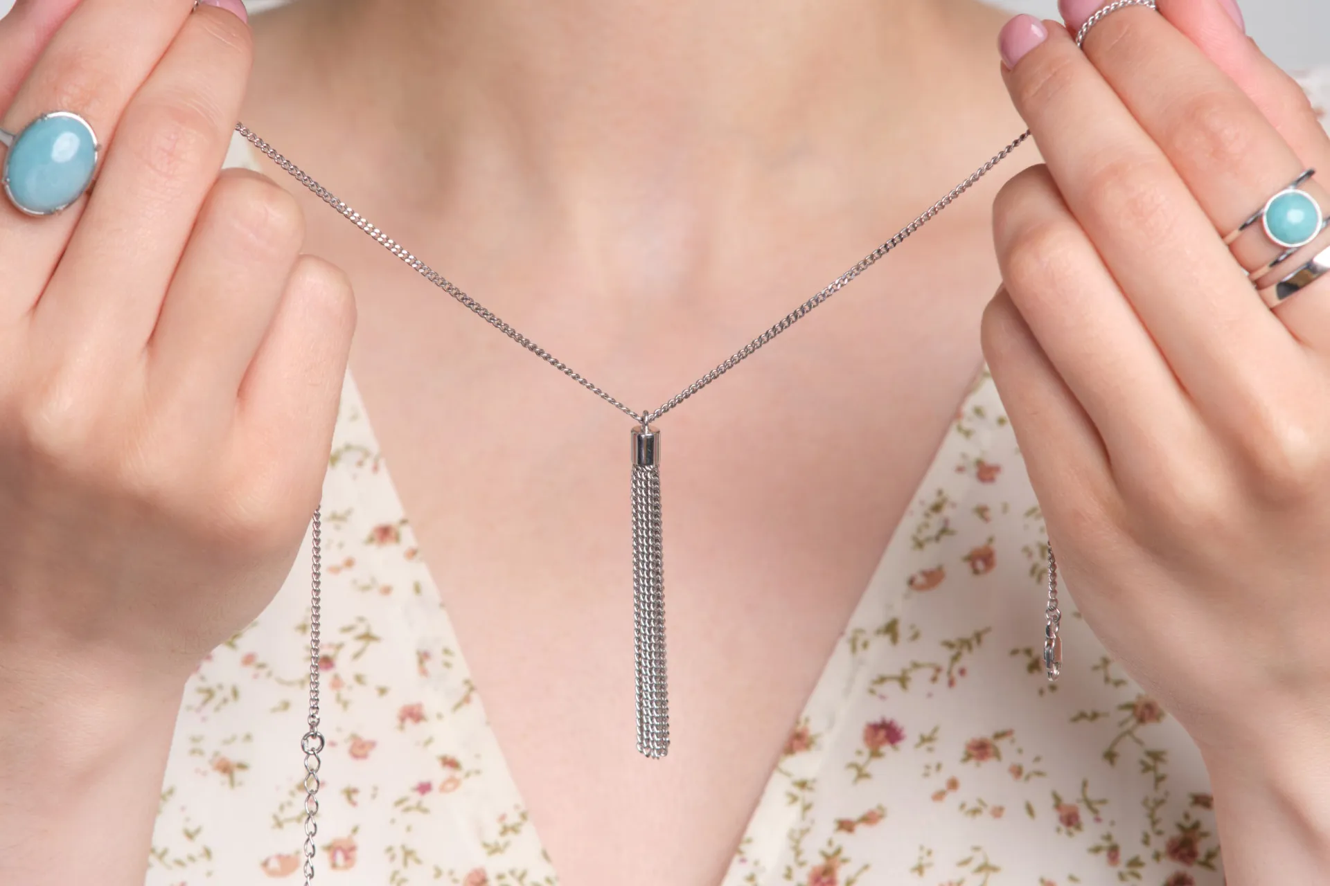 Mão adornada com anéis e pulseiras de ouro e prata para comparação.