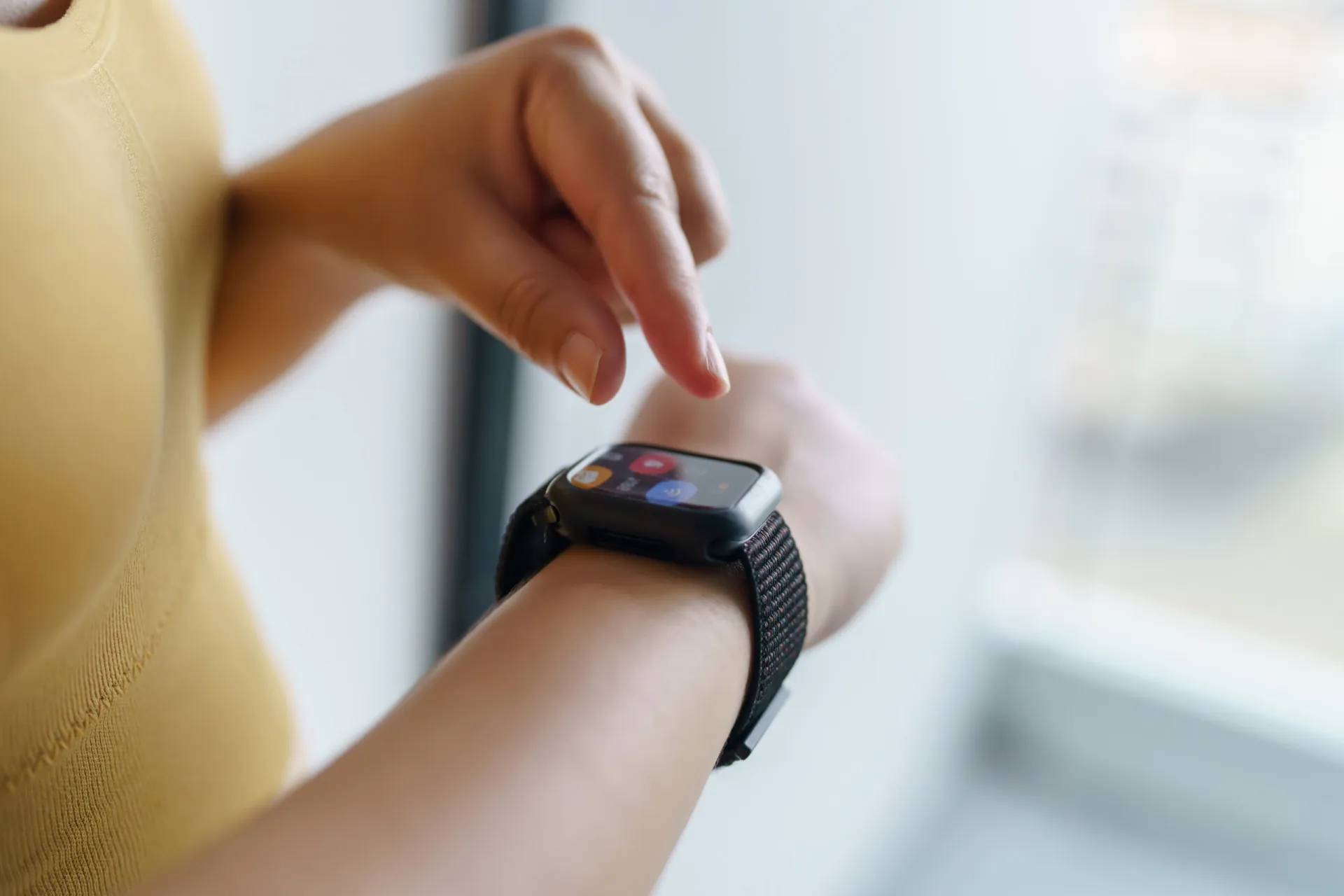 Pessoa olhando para um smartwatch que exibe dados de atividade física, como passos e calorias.