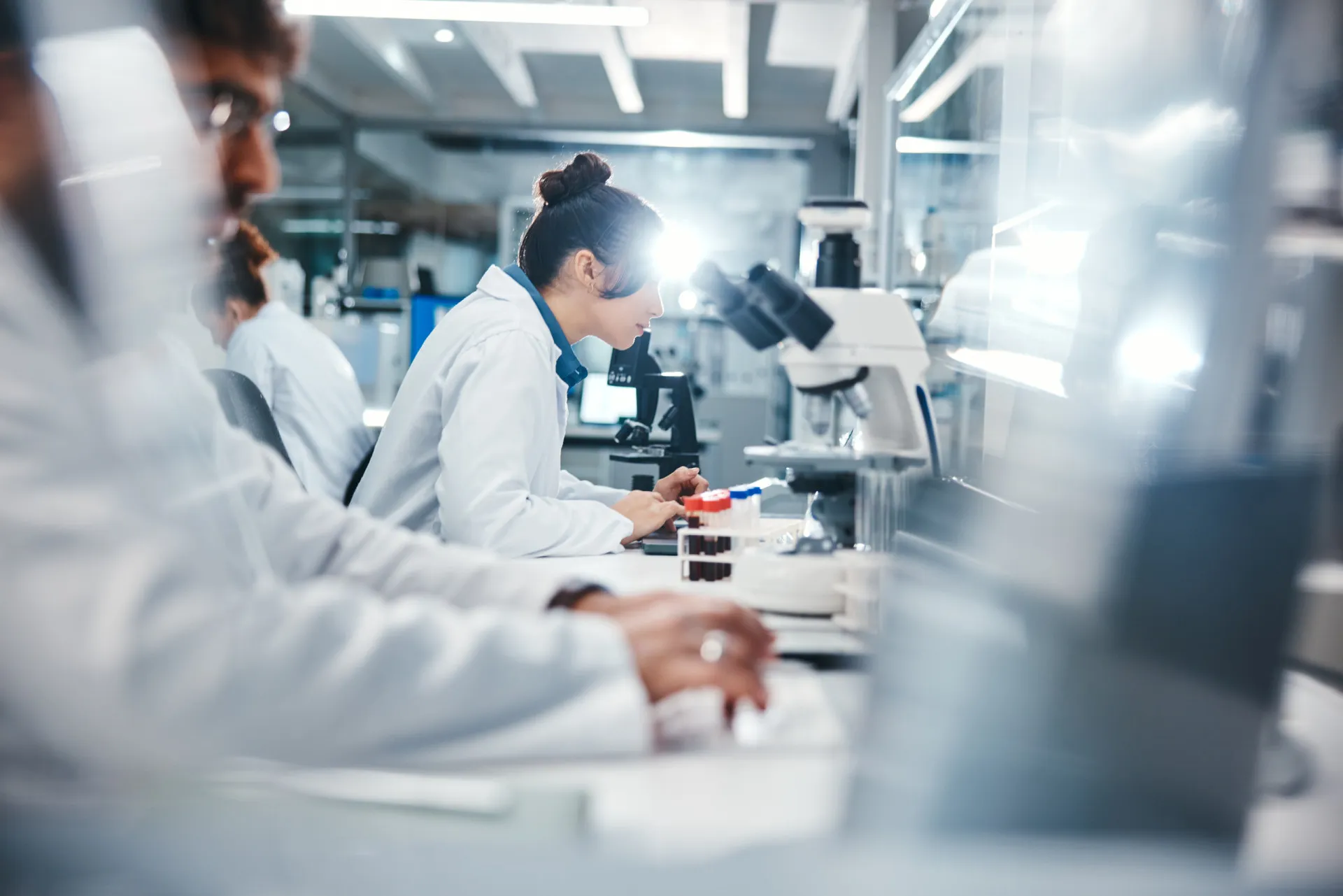 Cientista olhando para um modelo de DNA em um laboratório, representando a pesquisa sobre o NEAT.