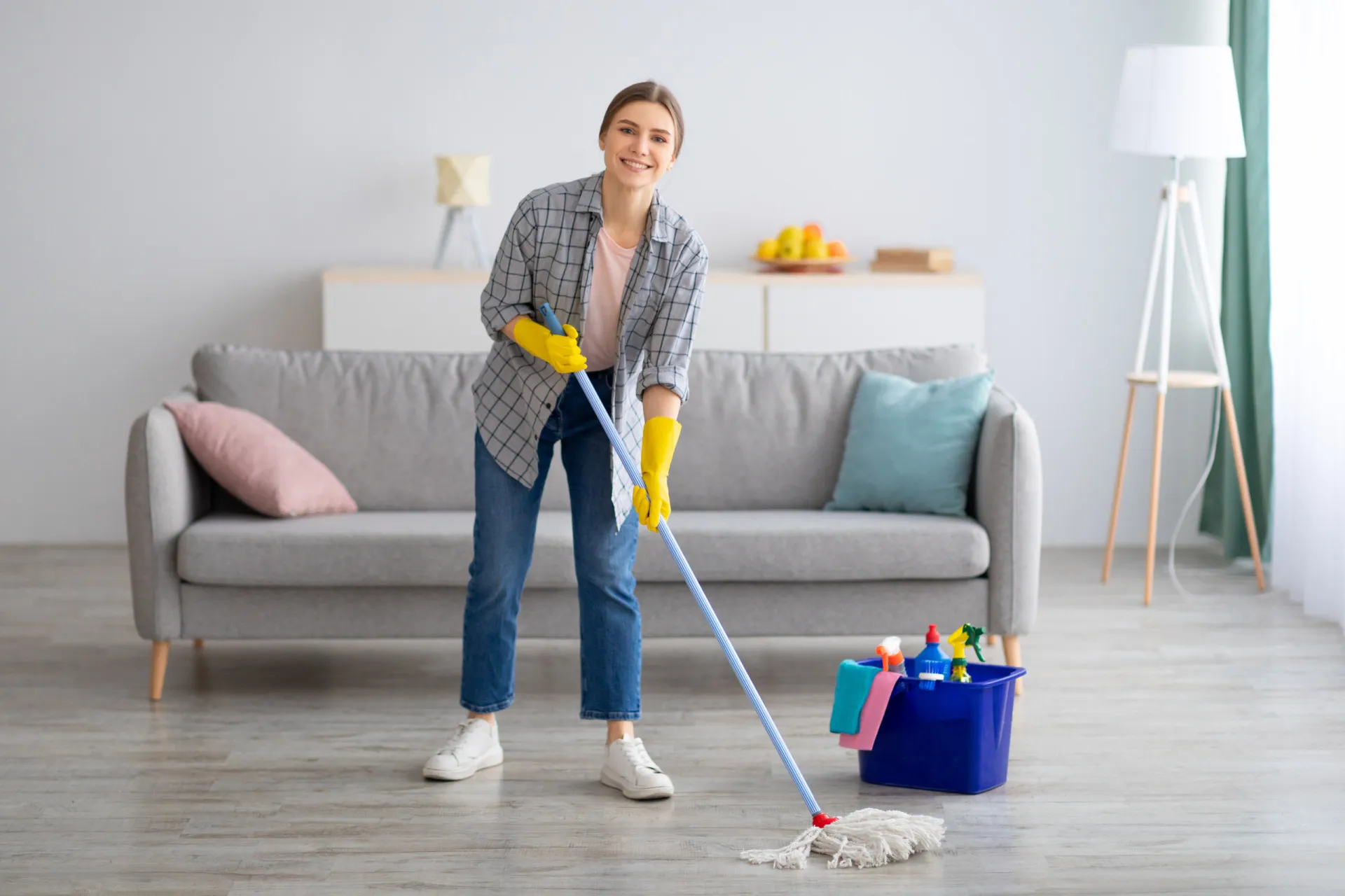 Homem aspirando o tapete da sala de estar com energia e movimento.