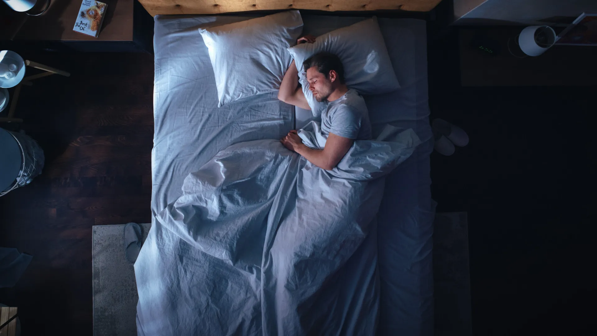 Mulher dormindo tranquilamente em uma cama confortável, ilustrando a importância do sono reparador.