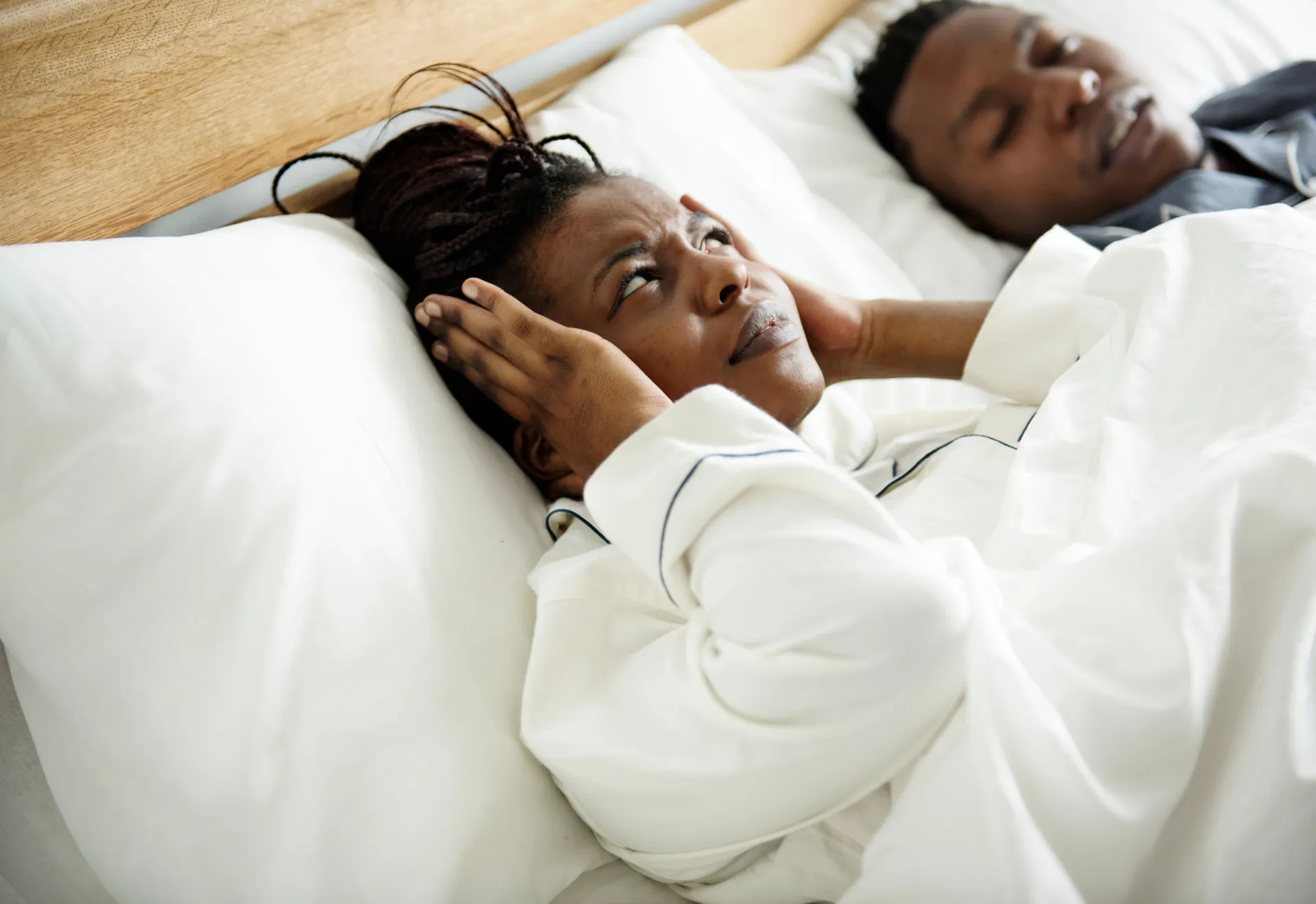 Relógio despertador tocando cedo pela manhã ao lado de uma cama.