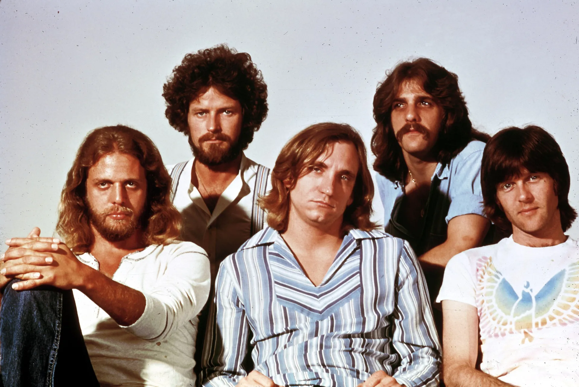 Os membros da banda Eagles posando juntos em um cenário desértico.