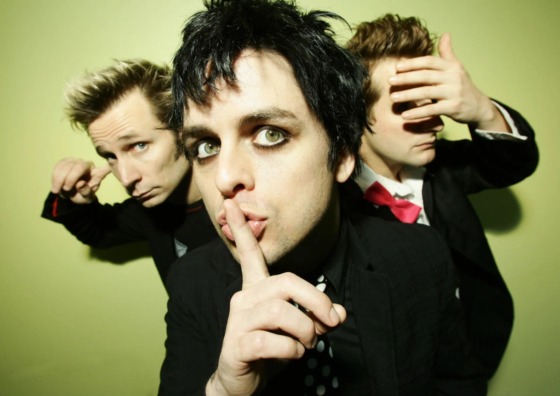 Billie Joe Armstrong, do Green Day, tocando sua guitarra com energia em um show.