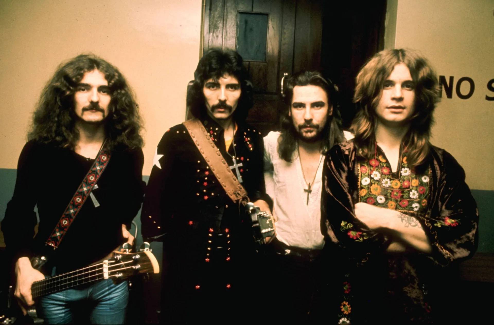 Os membros da banda Black Sabbath posando para uma foto em preto e branco nos anos 70.