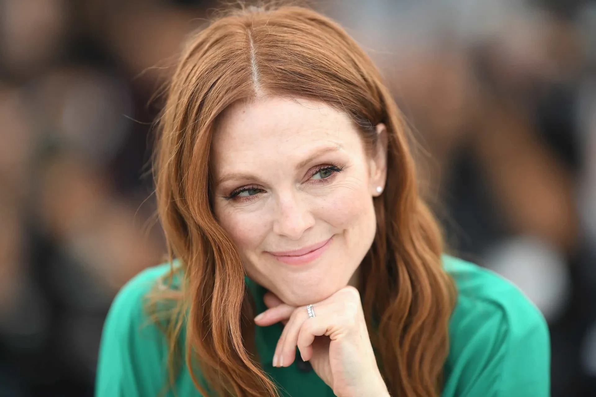 A atriz Julianne Moore com seus cabelos ruivos característicos, olhando para a câmera.