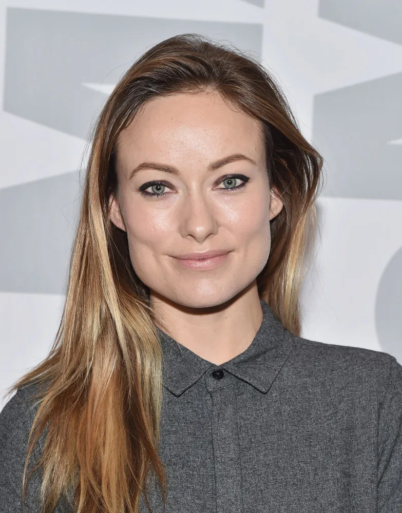 A atriz e diretora Olivia Wilde com um visual sofisticado e pele iluminada.