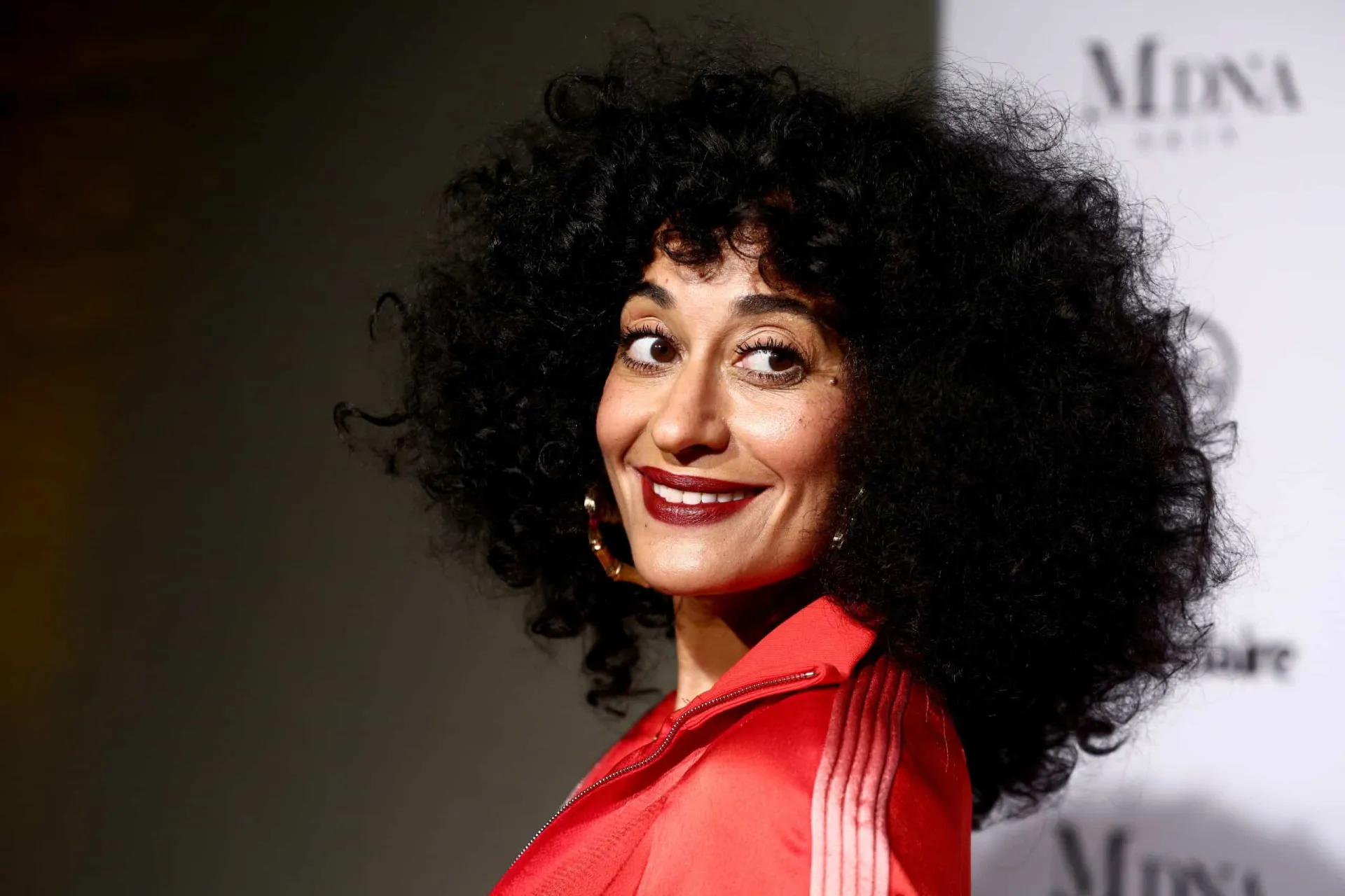 A atriz Tracee Ellis Ross rindo, mostrando sua pele vibrante e cheia de vida.