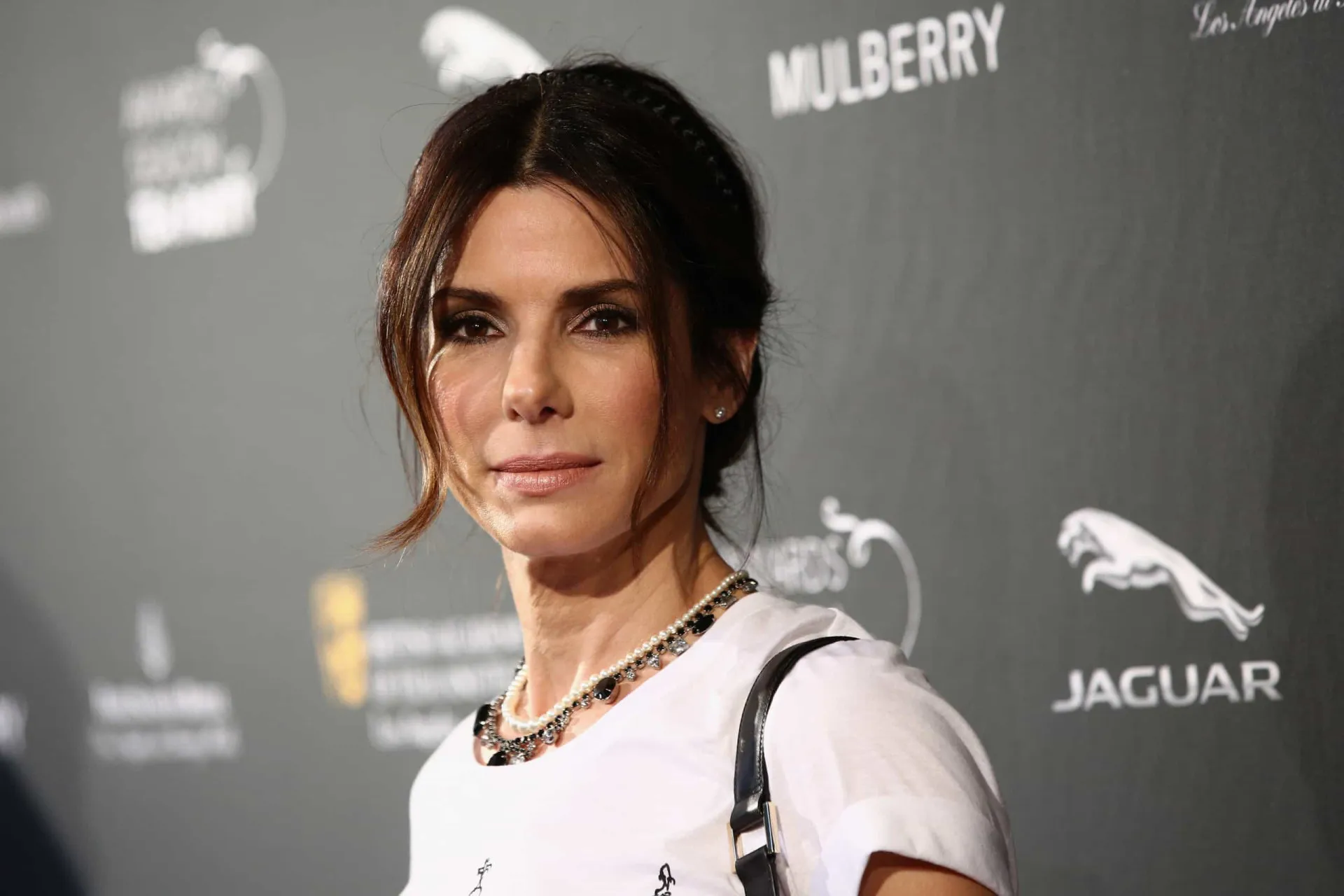 A atriz Sandra Bullock sorrindo em um evento, com sua beleza clássica em destaque.