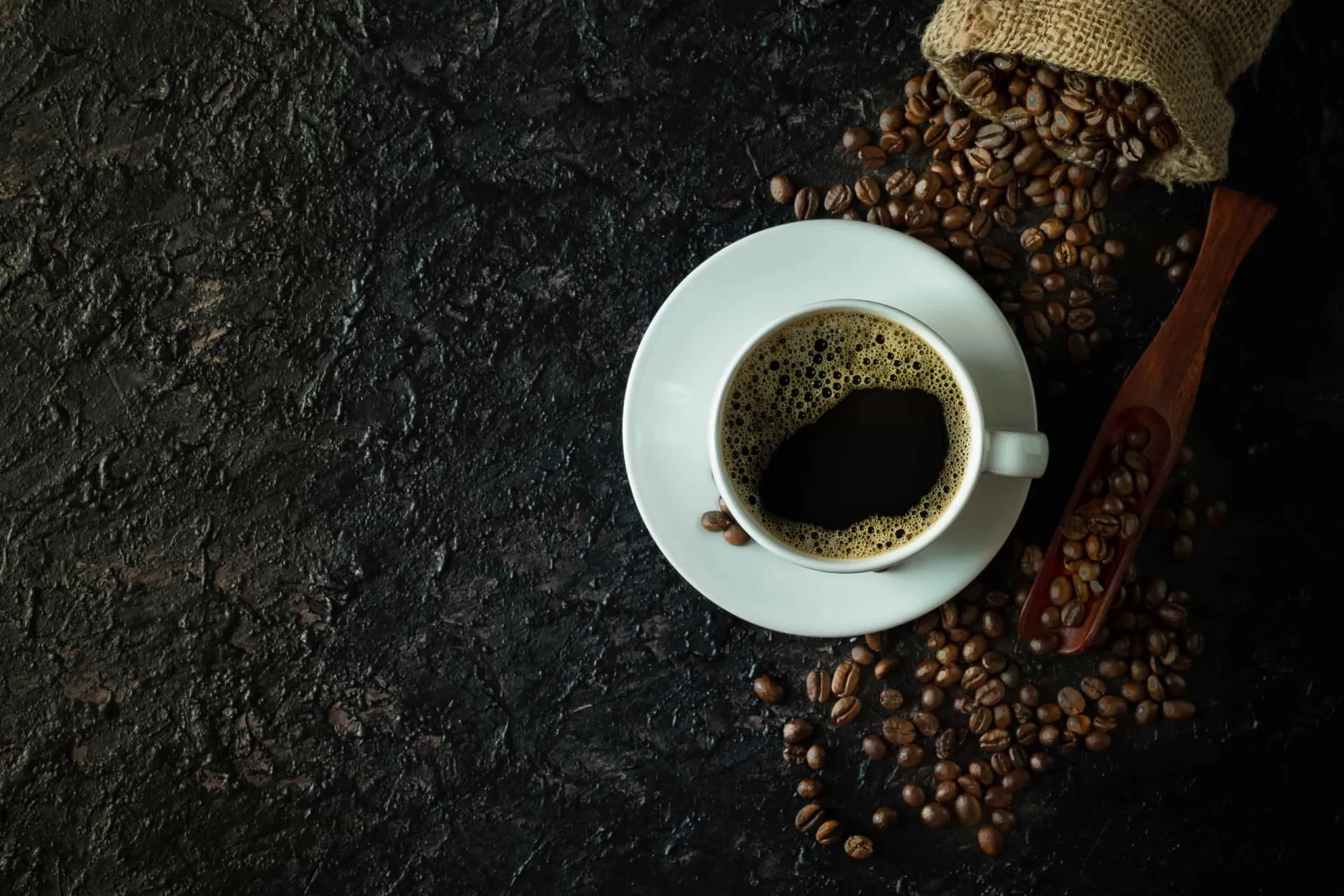 Grãos de café torrados e uma xícara de café fresco, a principal fonte de antioxidantes para muitas pessoas.