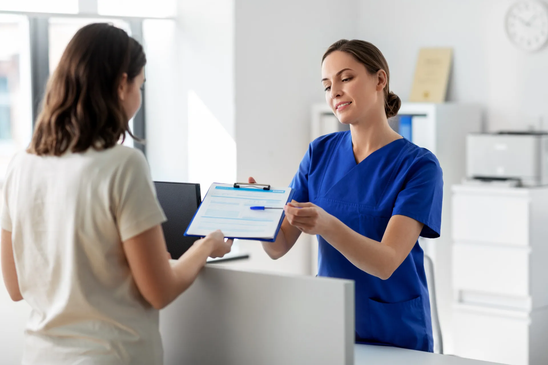 Médico com um estetoscópio conversando com um casal de idosos em um consultório.