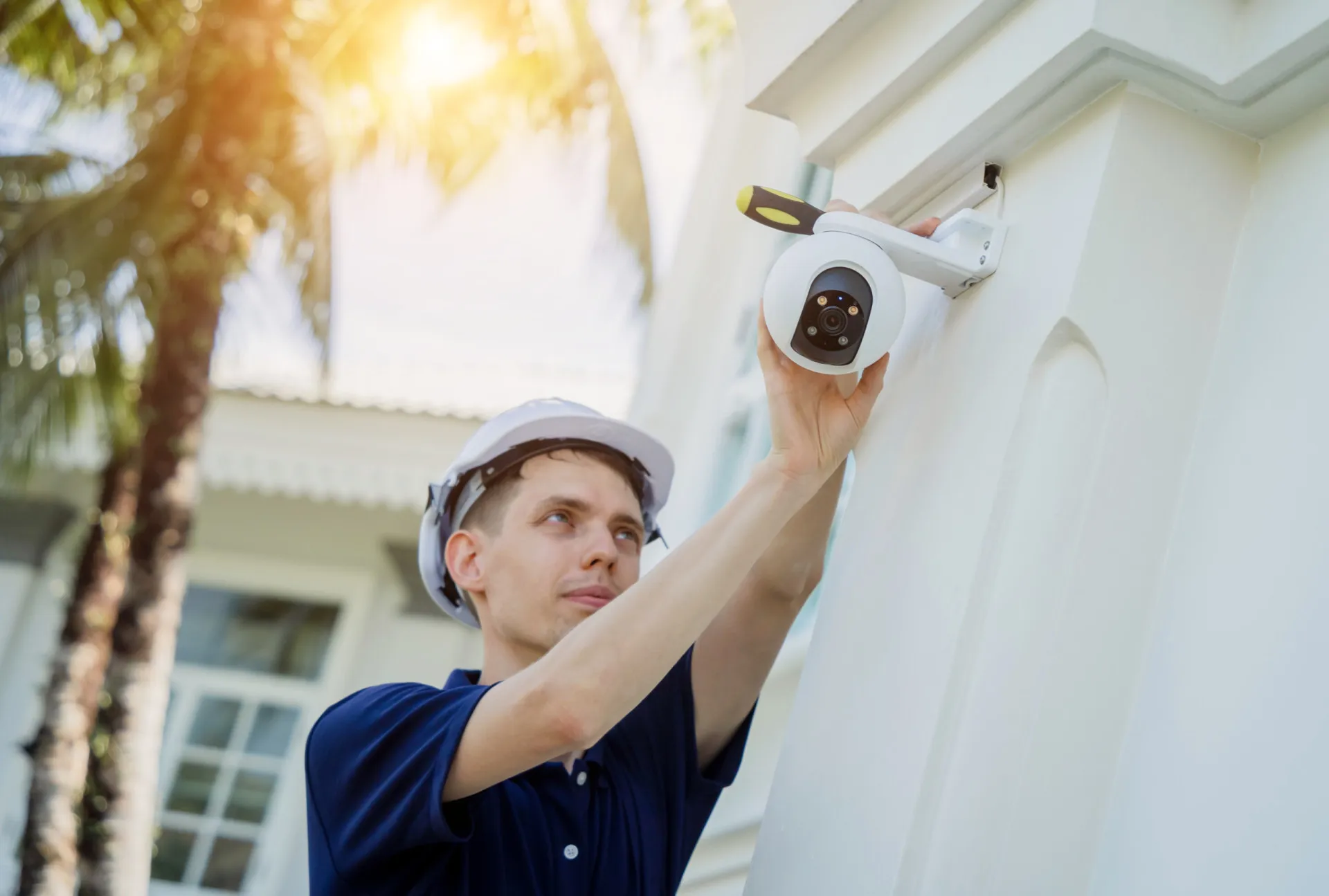 Mão digitando o código em um painel de alarme de um sistema de segurança residencial.