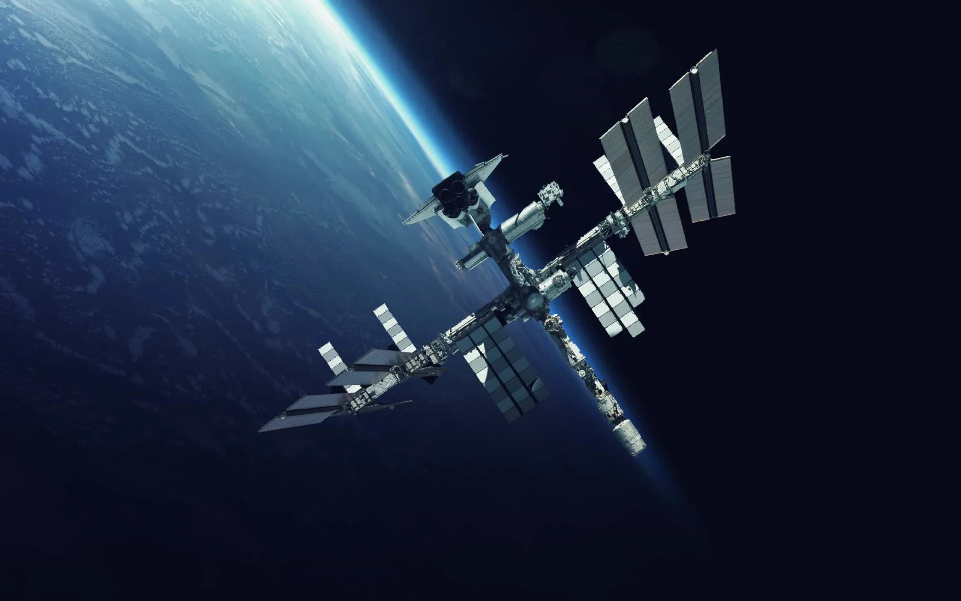A Estação Espacial Internacional orbitando o planeta Terra, com antenas apontadas para a superfície.
