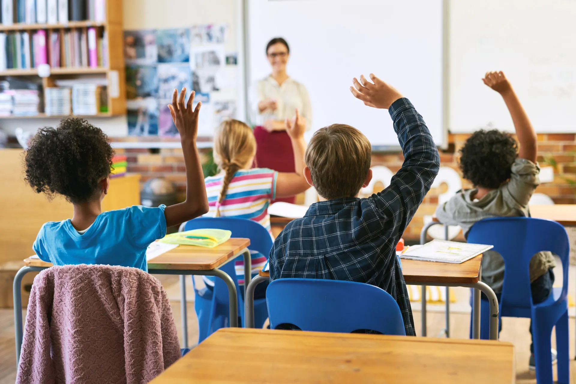 Sala de aula diversificada com alunos aprendendo, representando o investimento em educação.
