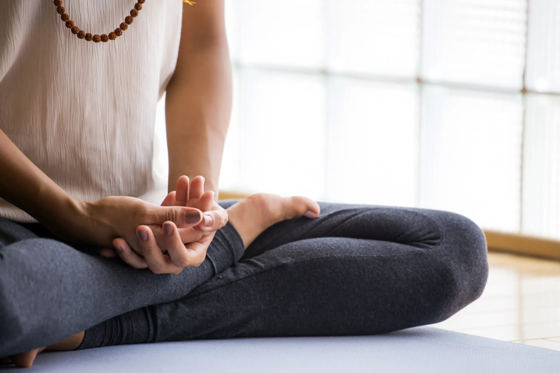 Uma pessoa meditando em um ambiente tranquilo, com uma expressão serena.
