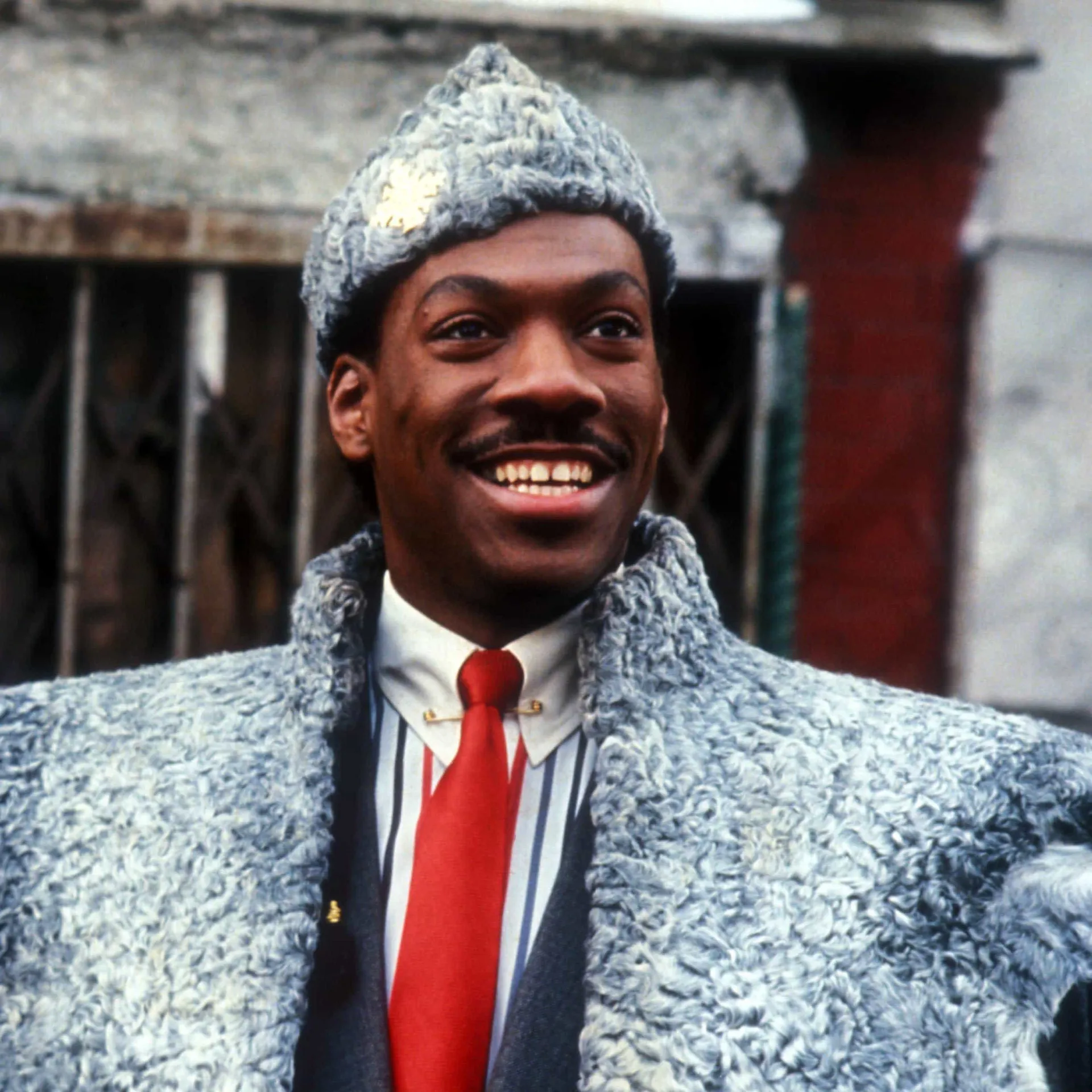 Eddie Murphy como o Príncipe Akeem, sorrindo em sua primeira experiência em Nova York.