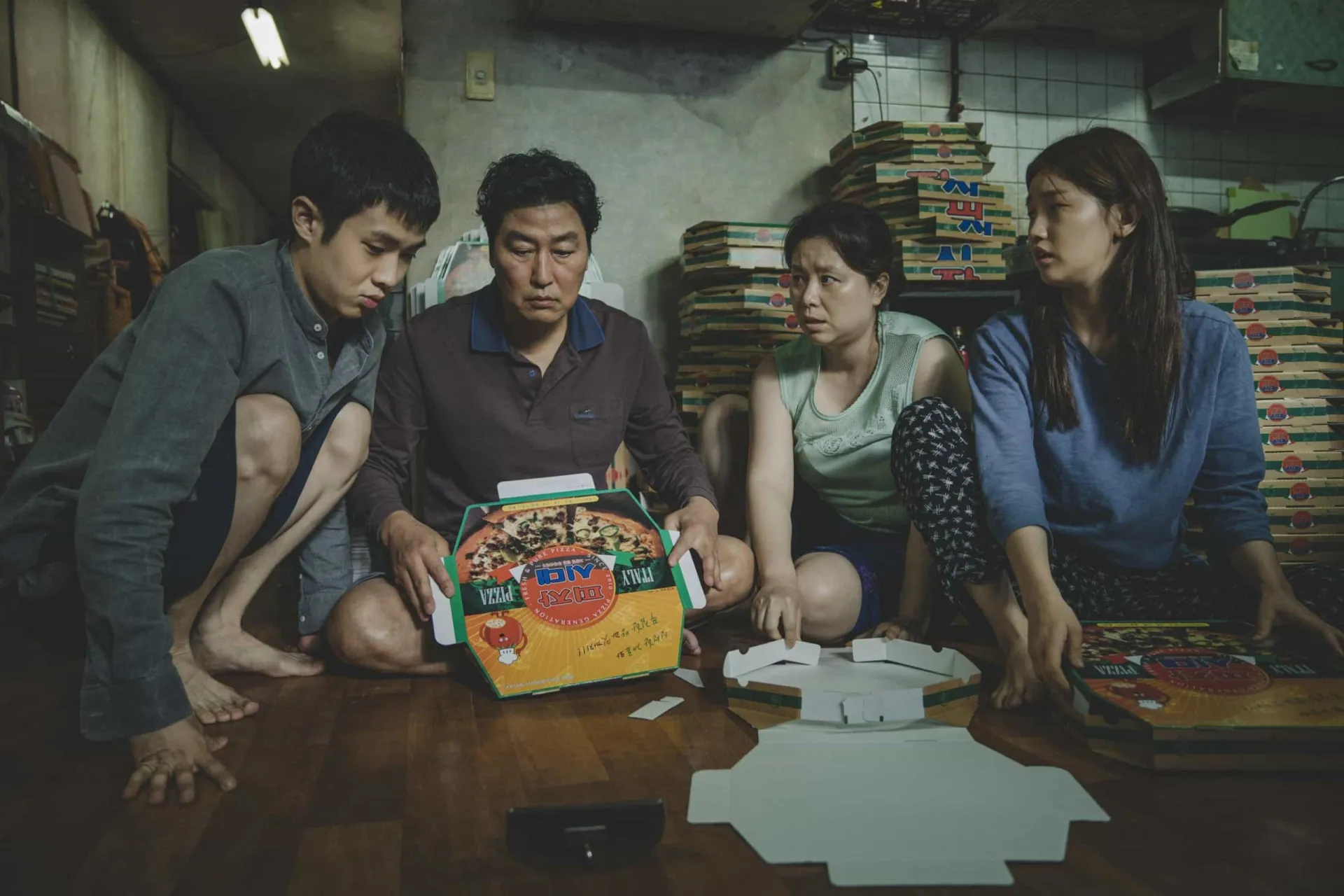 A família do filme 'Parasita' reunida em sua casa semi-subterrânea.