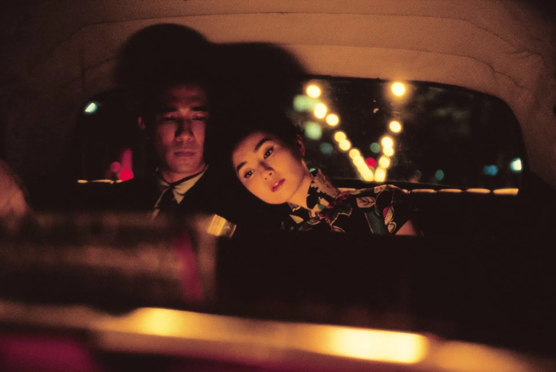 Maggie Cheung e Tony Leung em uma cena visualmente deslumbrante de 'Amor à Flor da Pele'.
