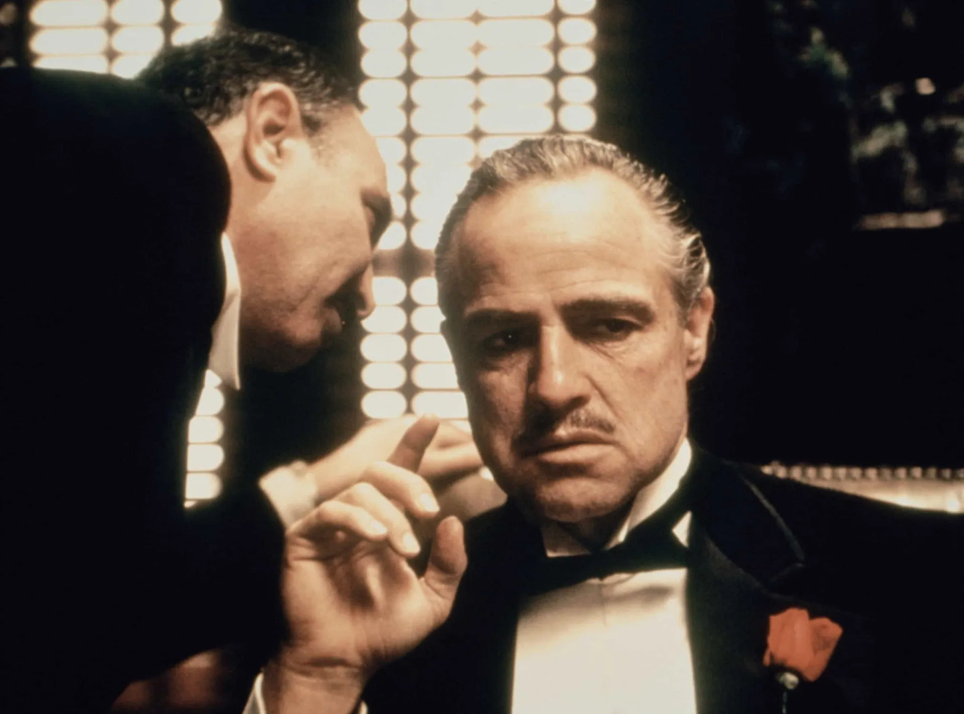 Marlon Brando como Don Vito Corleone, em uma cena sombria e imponente de 'O Poderoso Chefão'.