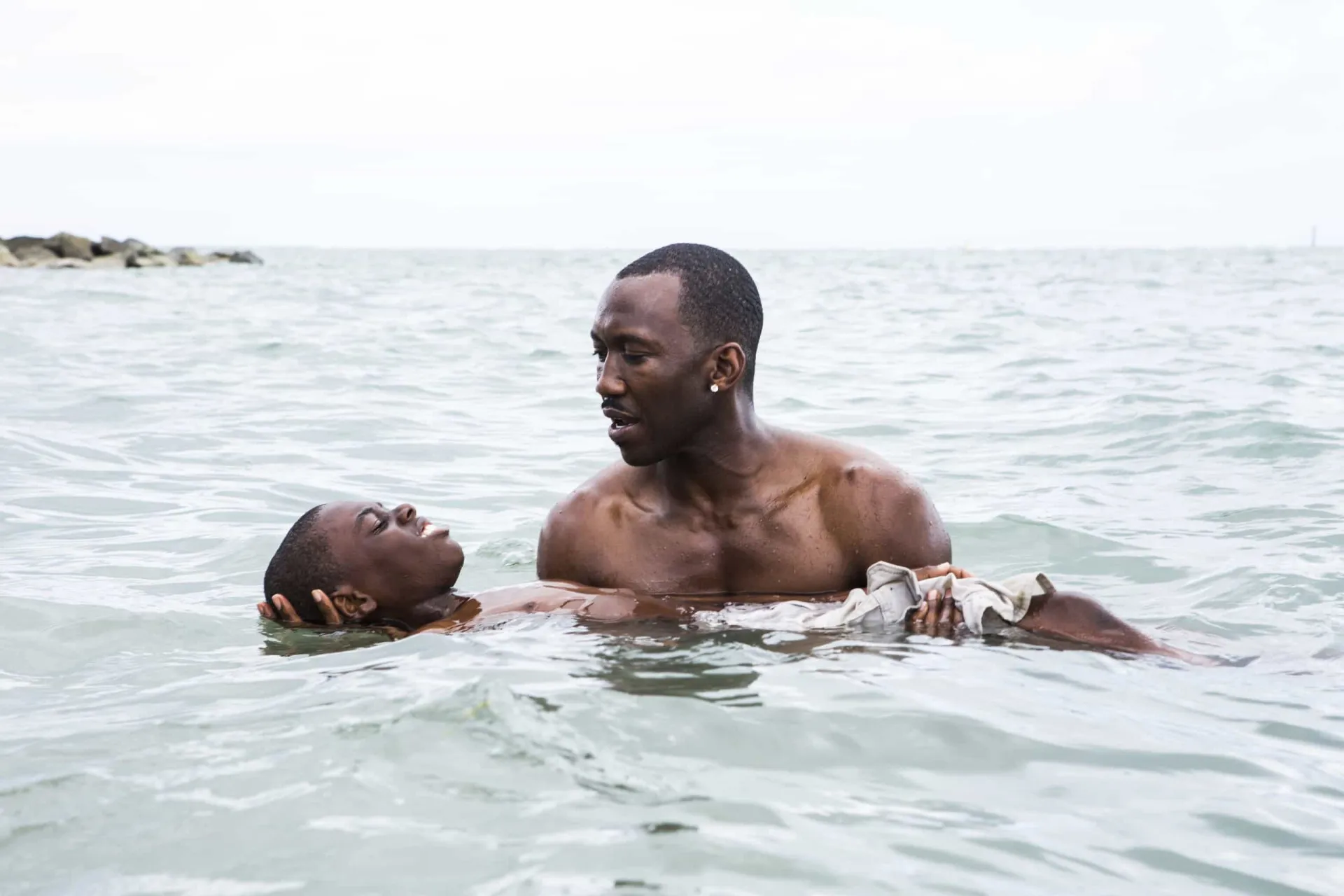 Cena do filme 'Moonlight' com Mahershala Ali e o jovem ator Alex Hibbert na praia.