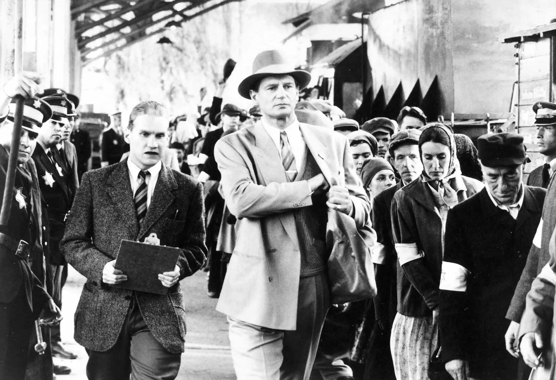 Liam Neeson como Oskar Schindler em uma cena preto e branco do filme 'A Lista de Schindler'.