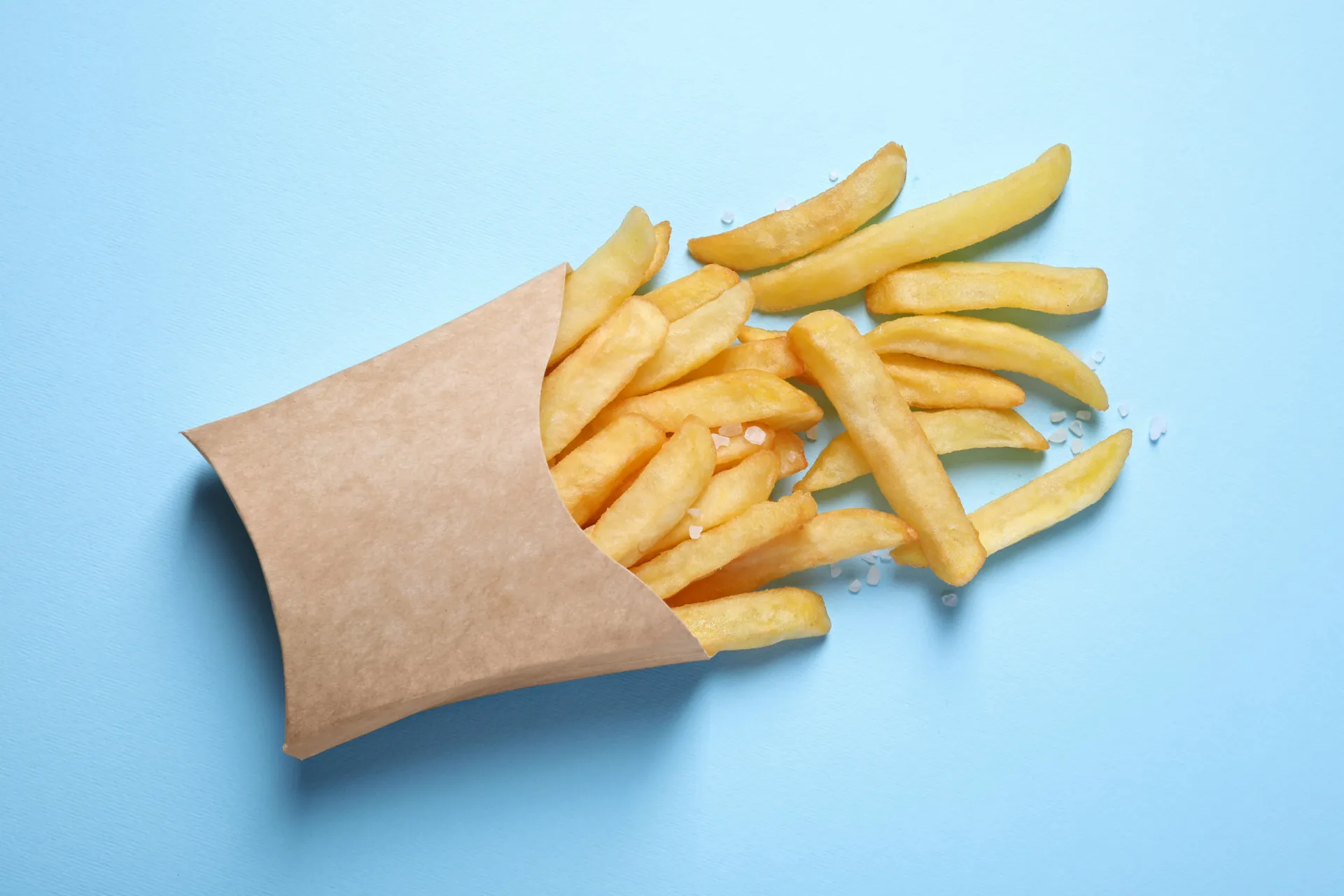 Um close-up de batatas fritas sendo preparadas em uma fritadeira com óleo borbulhante.
