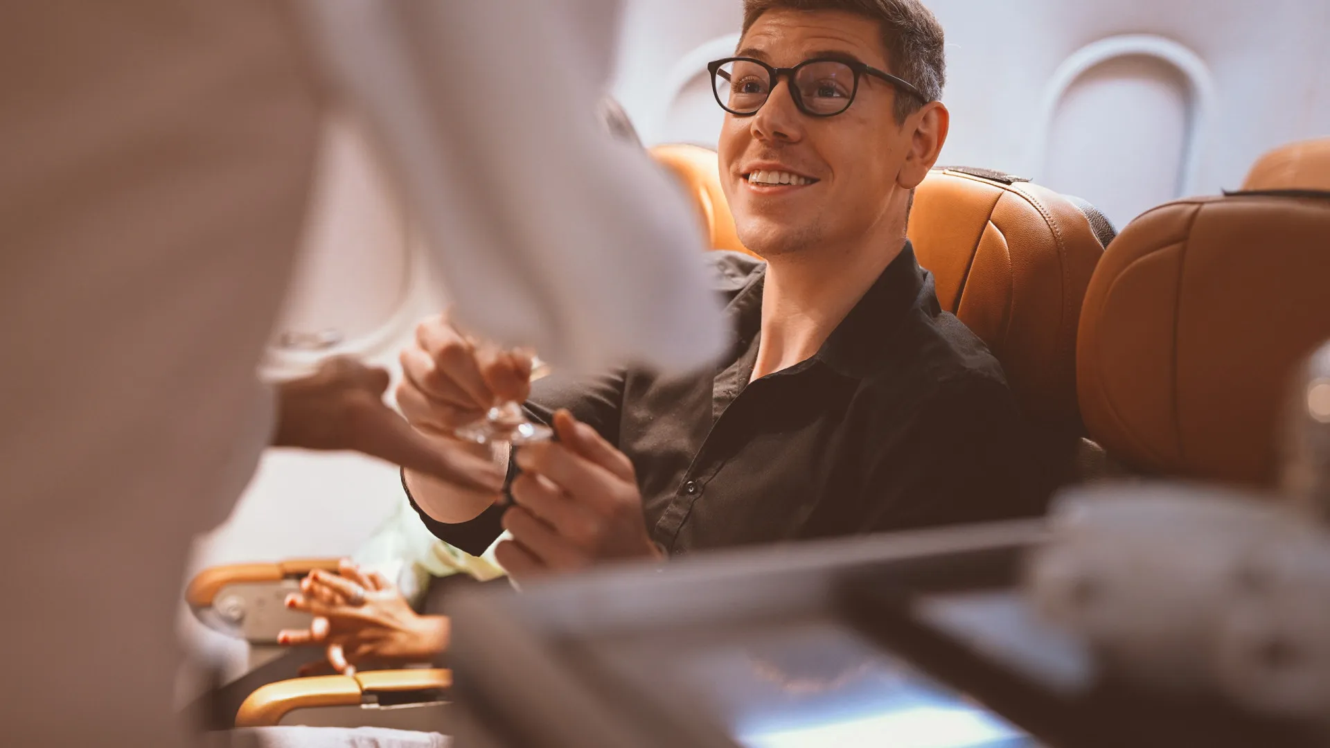 Uma taça de vinho tinto sendo servida por um comissário de bordo em um avião.