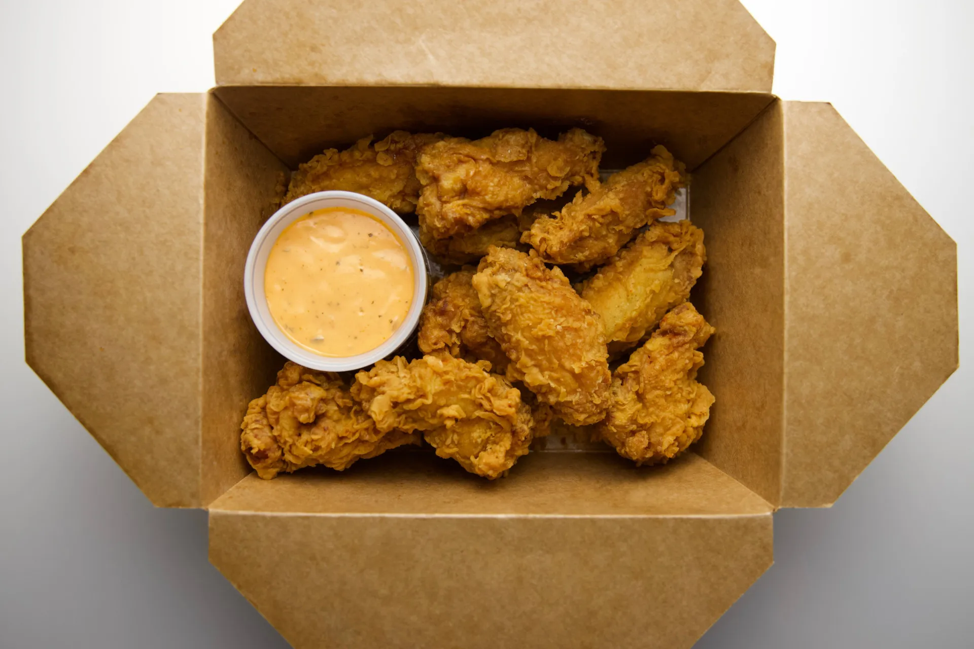 Prato com batatas fritas e frango frito, representando alimentos gordurosos.