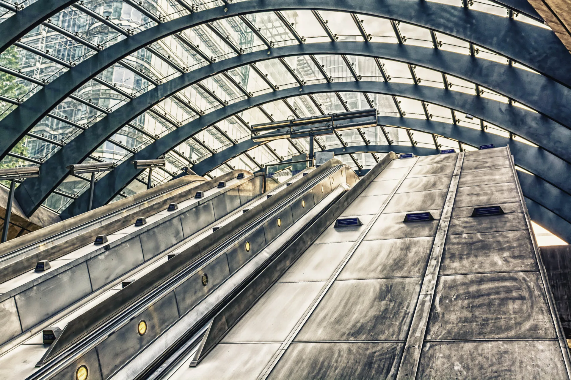 Arquitetura moderna e escadas rolantes da estação de metrô de Canary Wharf, em Londres.