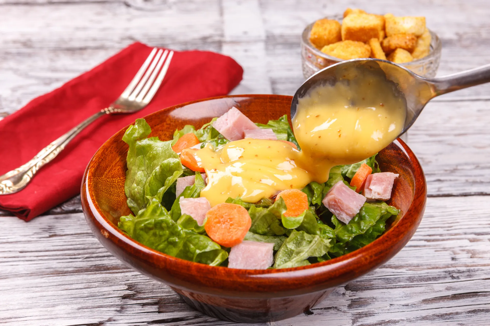 Azeite de oliva extra virgem sendo derramado sobre uma salada fresca.