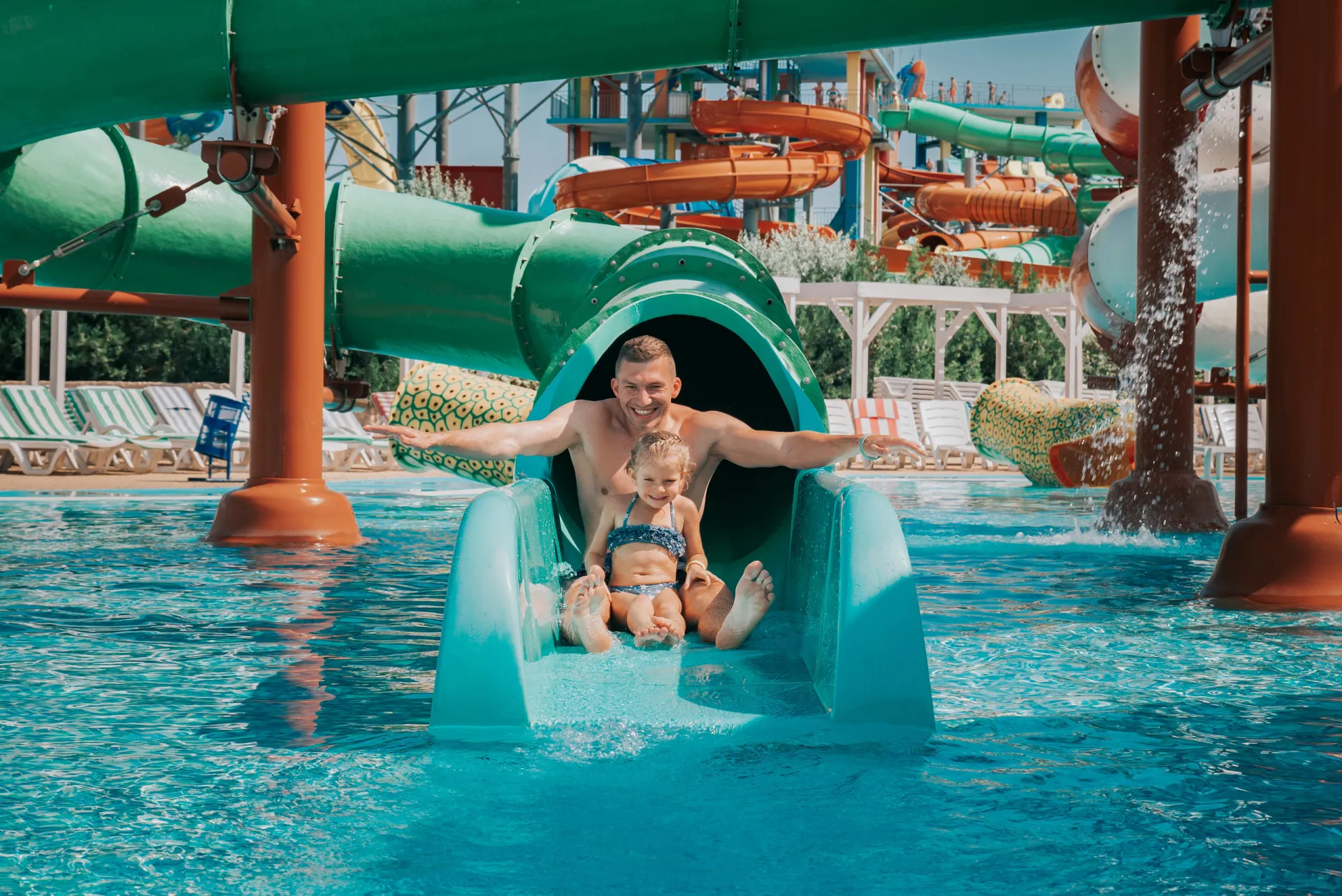 Pessoas se divertindo em uma piscina de ondas lotada em um parque aquático.