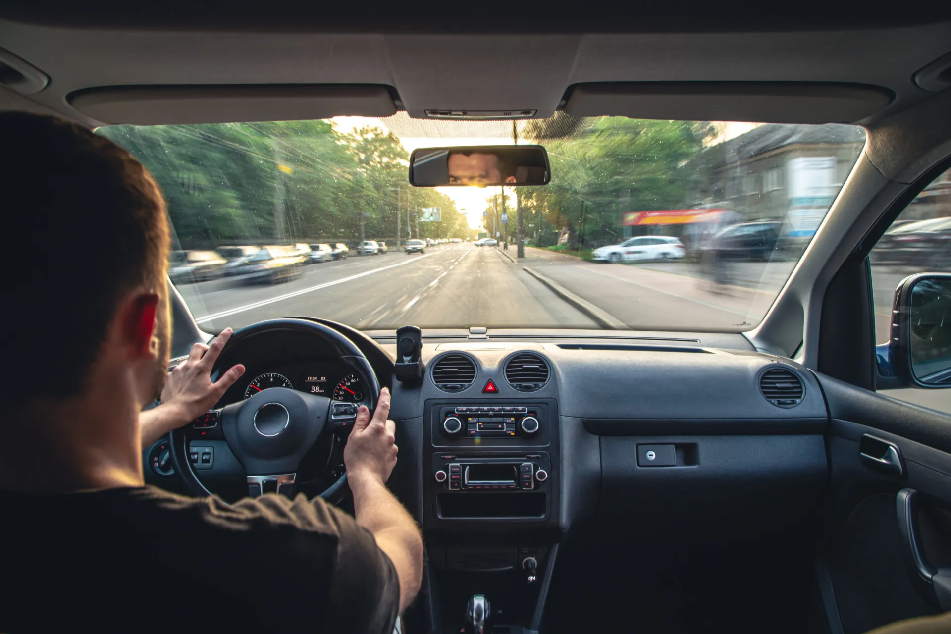 O painel de um carro visto por dentro, com a luz do sol entrando pelo para-brisa.