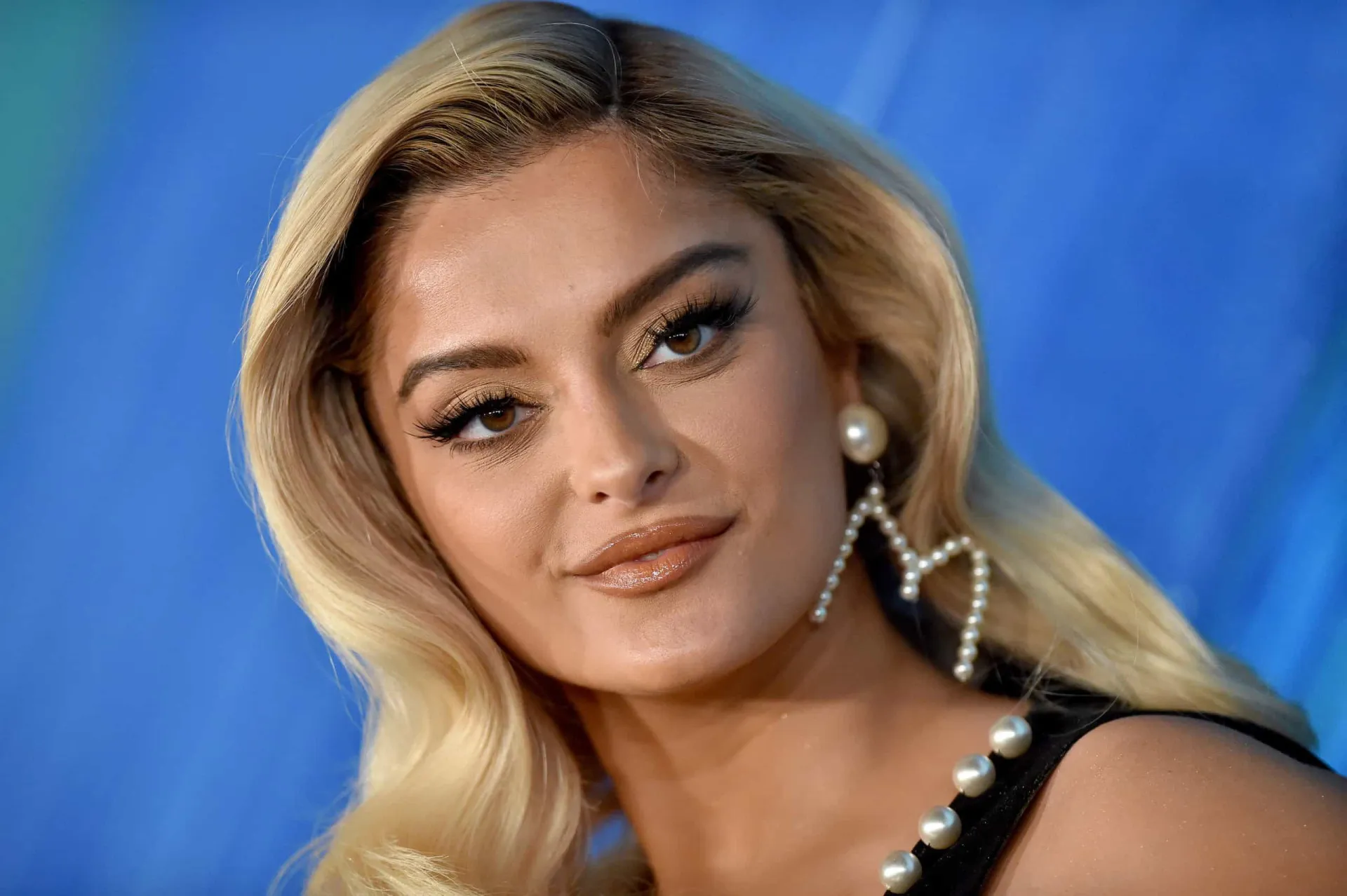 Bebe Rexha ajustando seu blazer para evitar um acidente de guarda-roupa no programa de Jimmy Fallon.