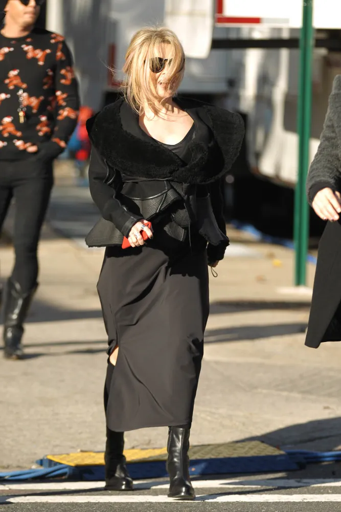 Helena Bonham Carter lutando para controlar seu vestido e chapéu contra uma forte ventania.