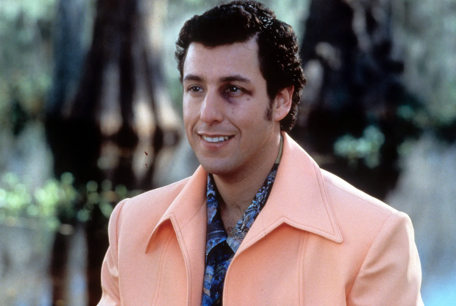 Adam Sandler em uma cena de um de seus filmes, fazendo uma careta engraçada.