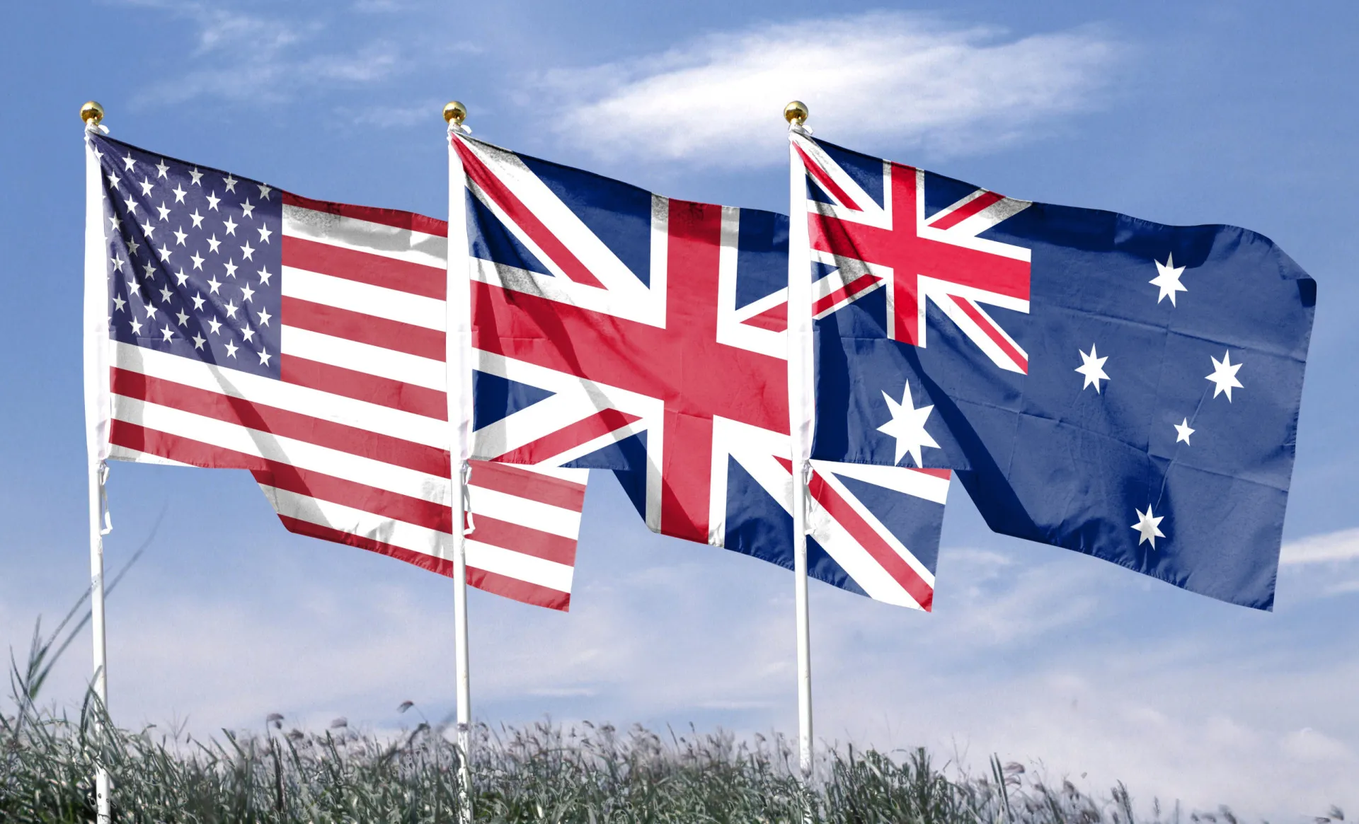 Bandeiras da Austrália, Reino Unido e Estados Unidos juntas, simbolizando sua aliança militar.