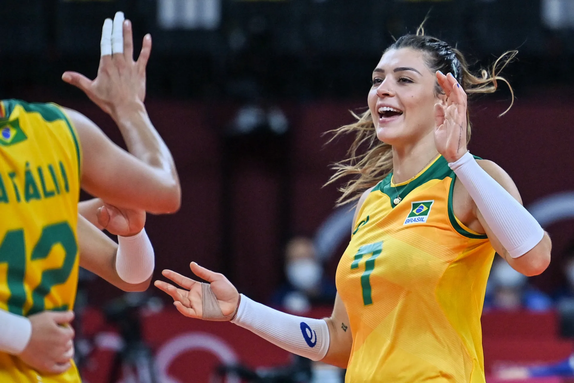 A jogadora de vôlei Rosamaria Montibeller comemorando um ponto com intensidade.