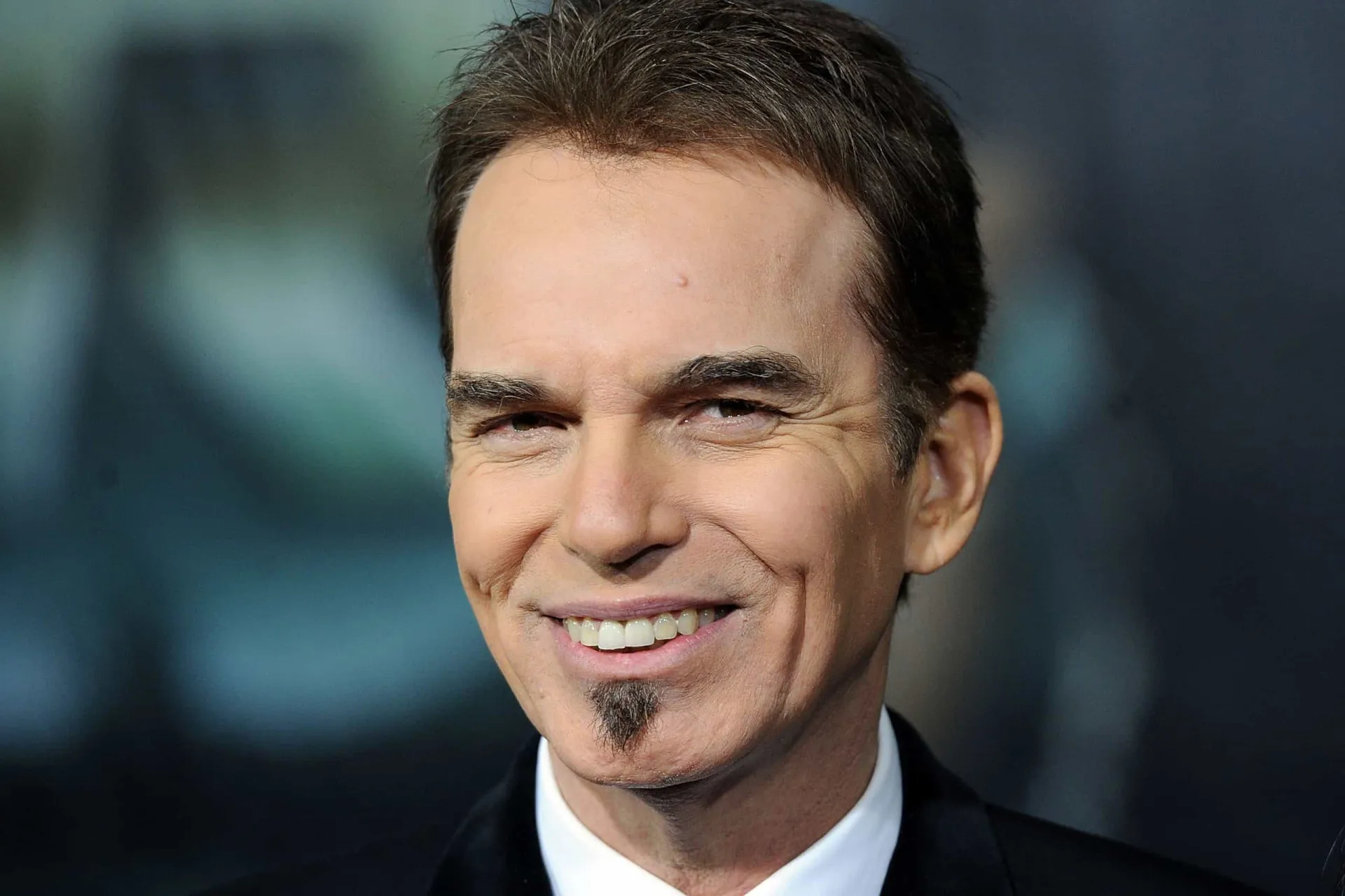 Billy Bob Thornton com seu característico cavanhaque e um olhar misterioso e intenso.