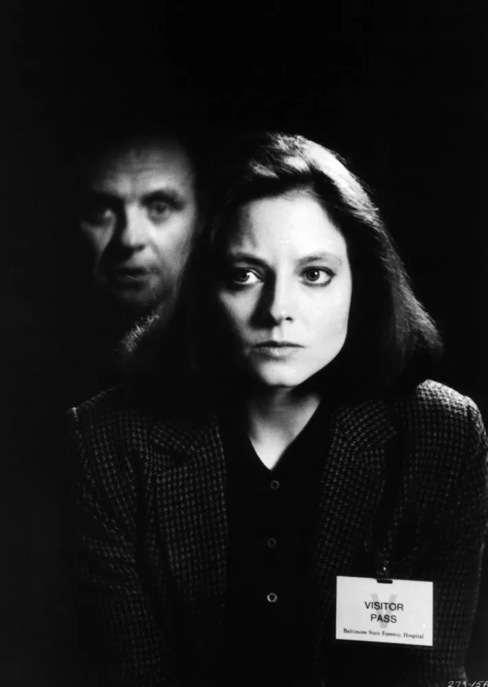 Anthony Hopkins como Hannibal Lecter em 'O Silêncio dos Inocentes', olhando intensamente através das grades de sua cela.
