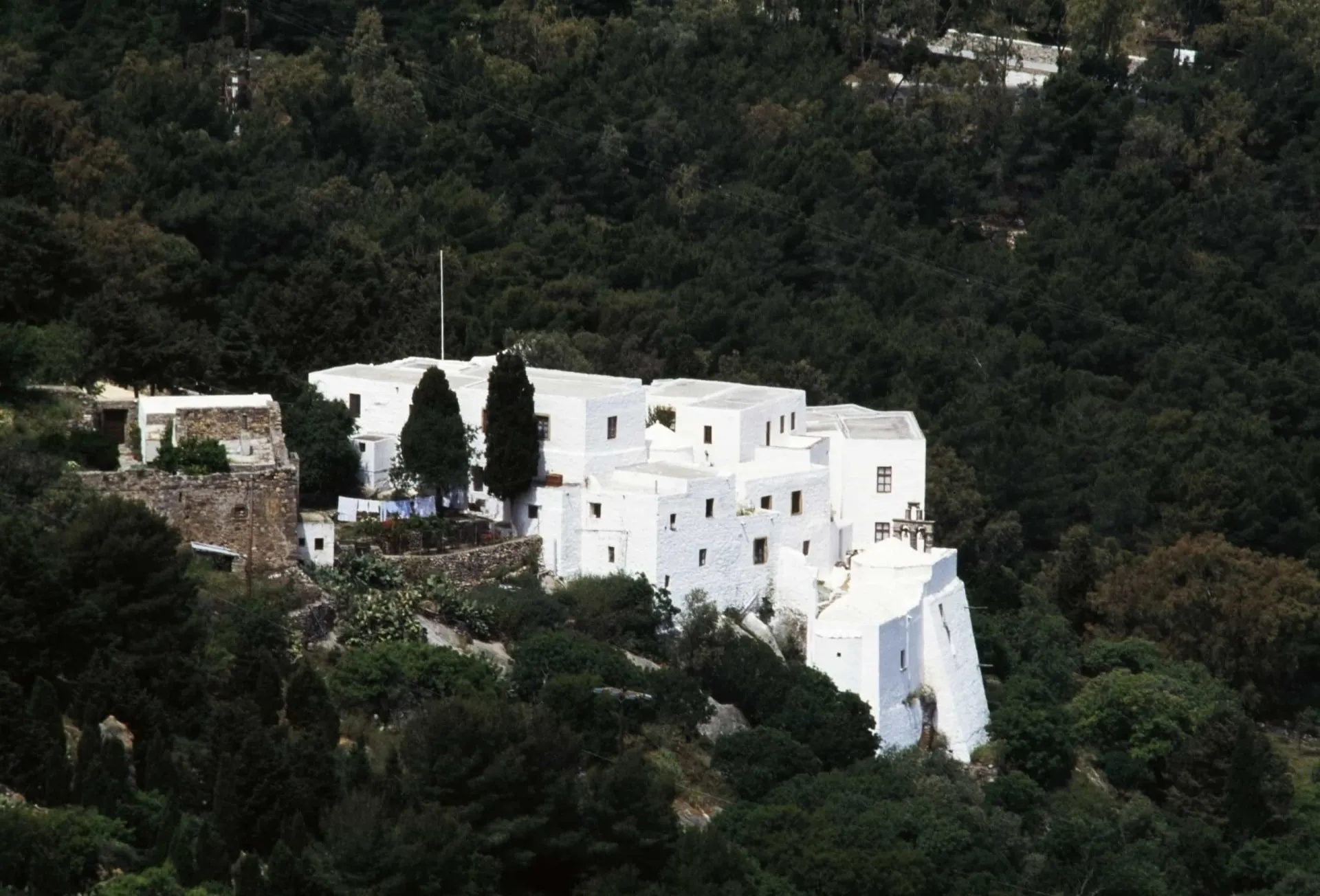 Interior da Caverna do Apocalipse em Patmos, com ícones religiosos e uma atmosfera sagrada.