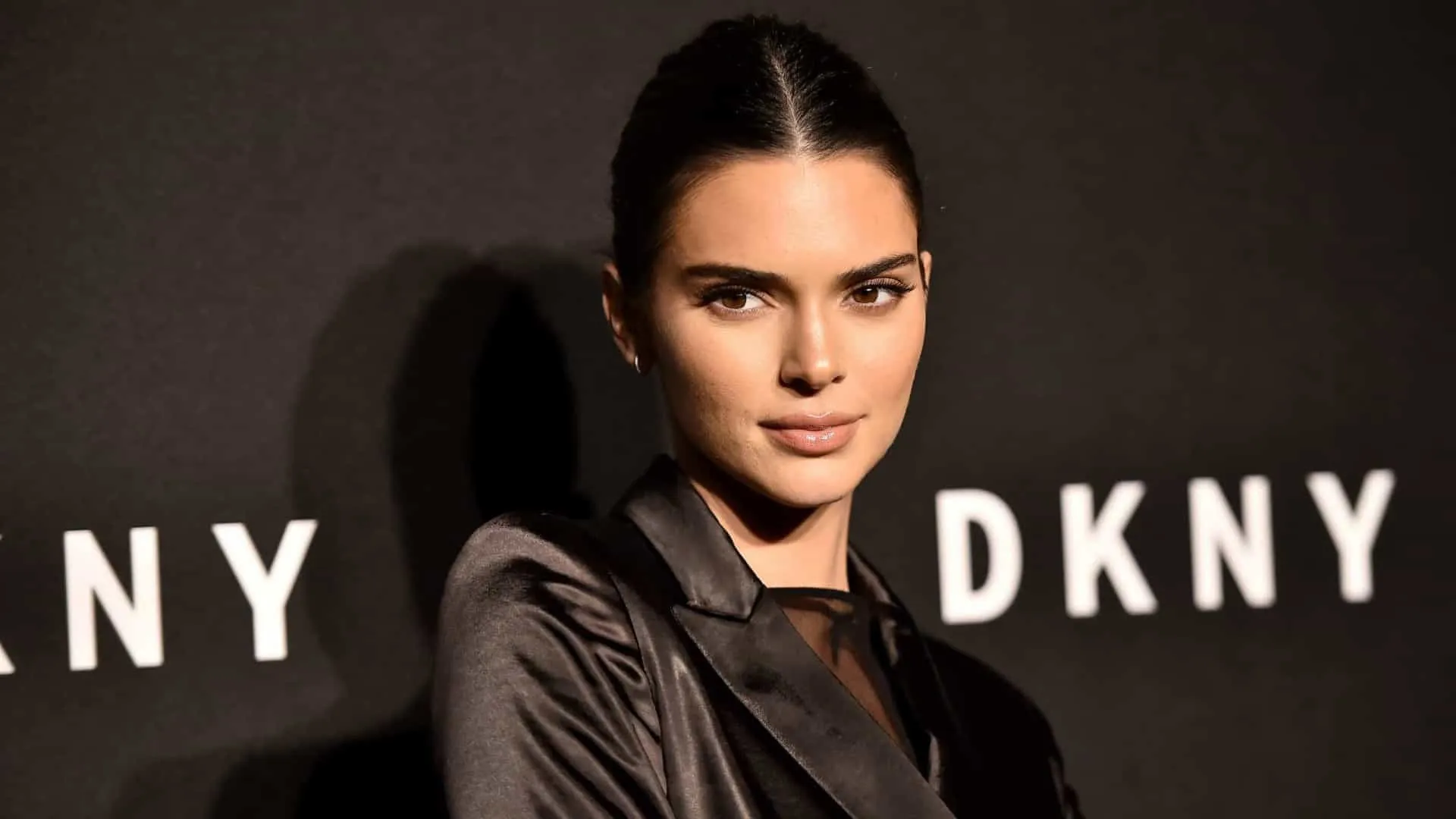 A modelo Kendall Jenner em um desfile de moda, exibindo sua postura elegante.