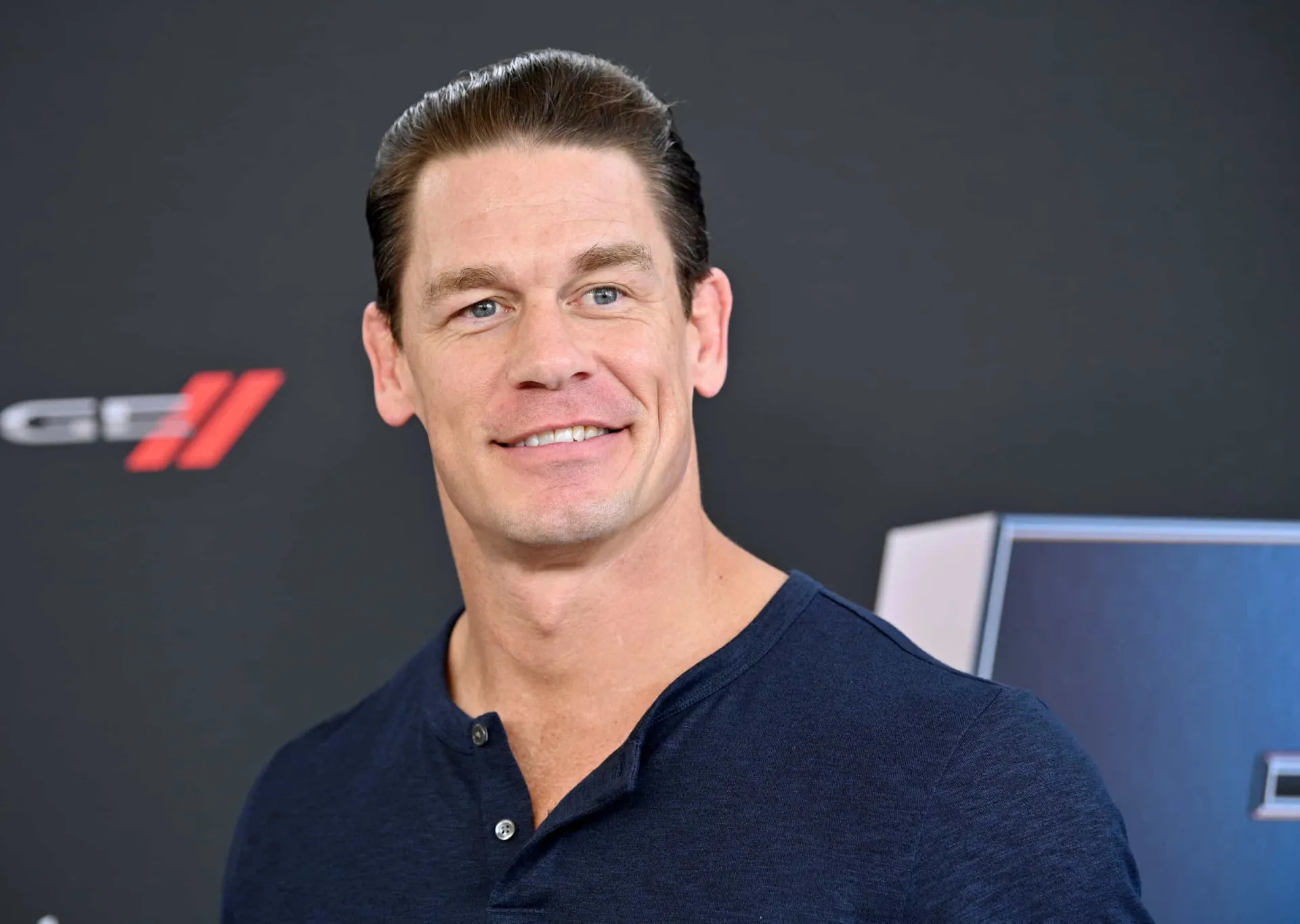 O lutador e ator John Cena com expressão séria, destacando seu porte físico imponente.